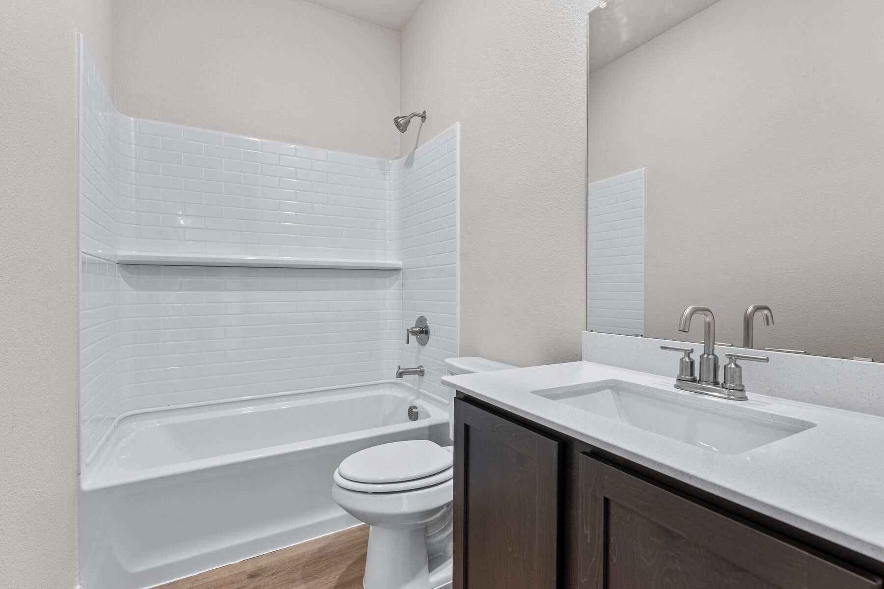 The secondary bathroom has a sprawling vanity and a shower-tub combo.