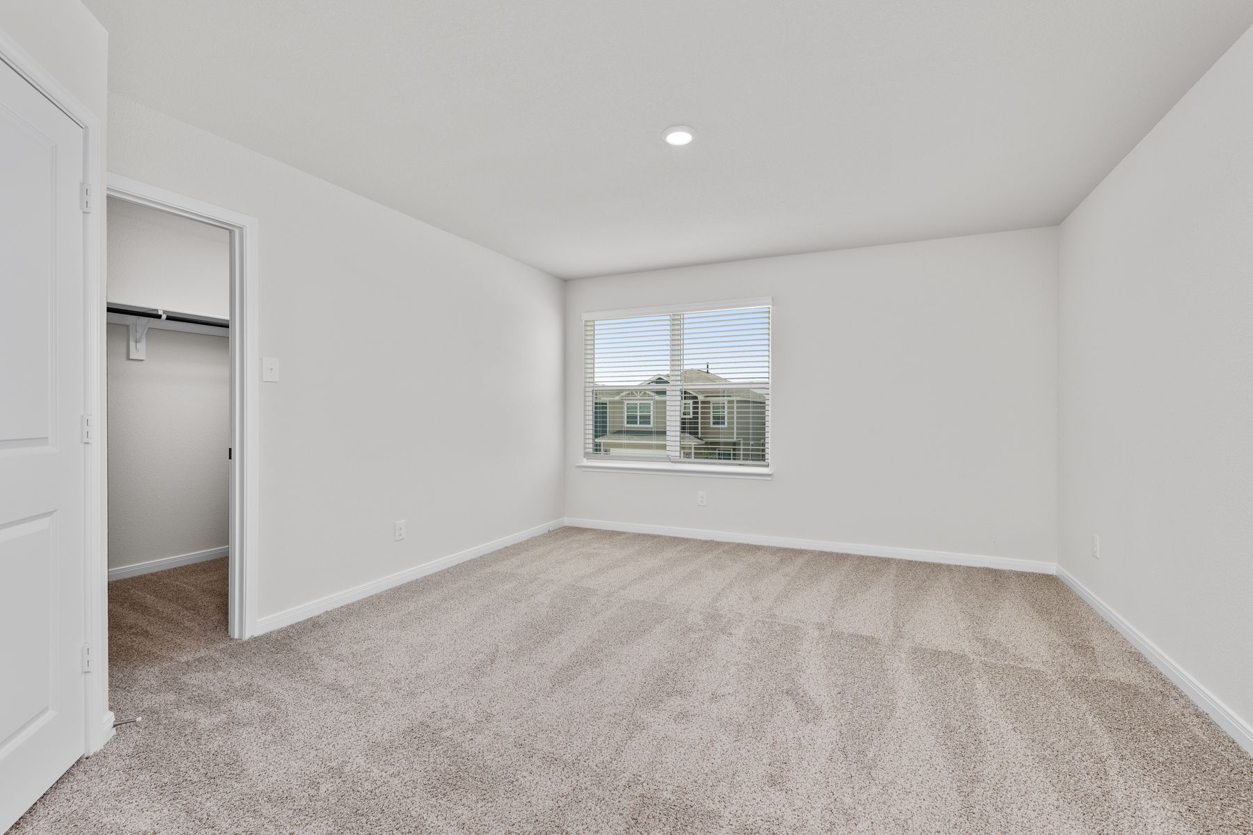 The master bedroom is spacious and has a large window.