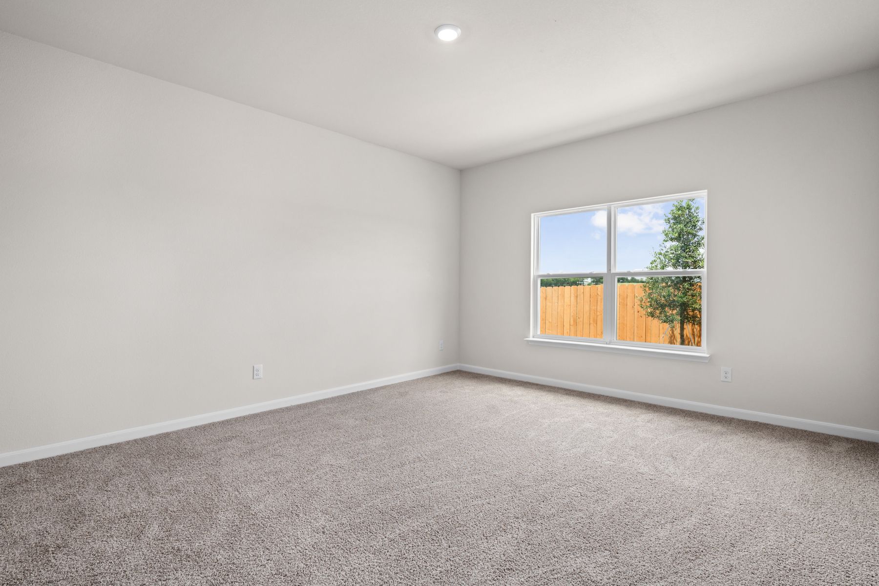 The master bedroom is spacious and has a large window.