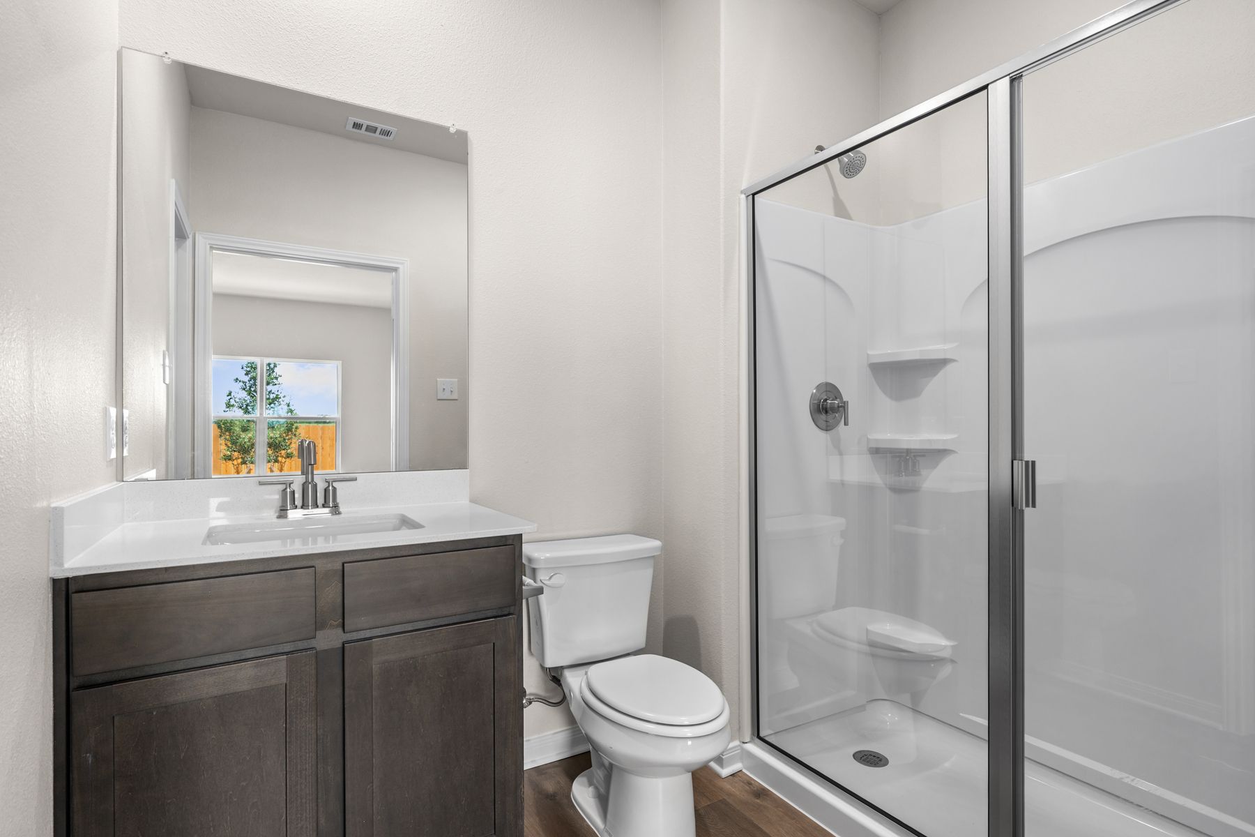 The master bathroom has a vanity and shower-tub combo.