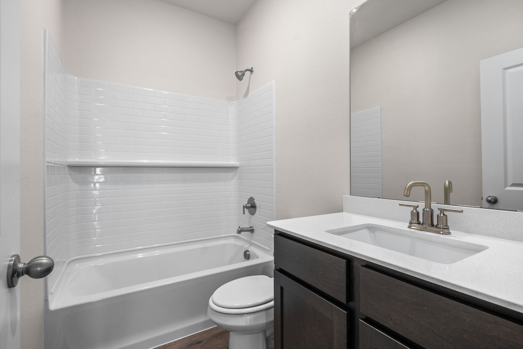 The secondary bathroom has a sprawling vanity and a shower-tub combo.