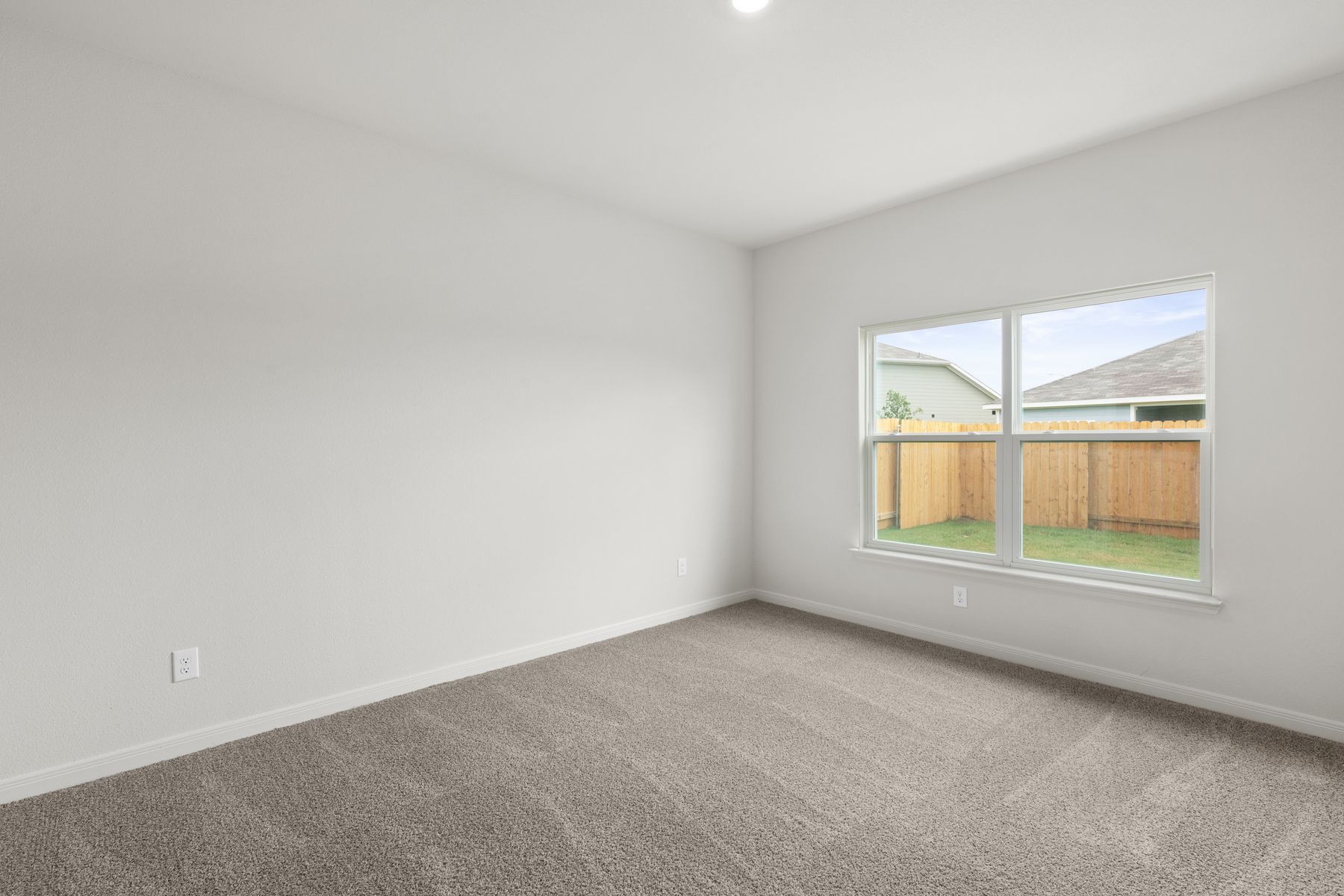 The master bedroom is spacious and has a wonderful window.