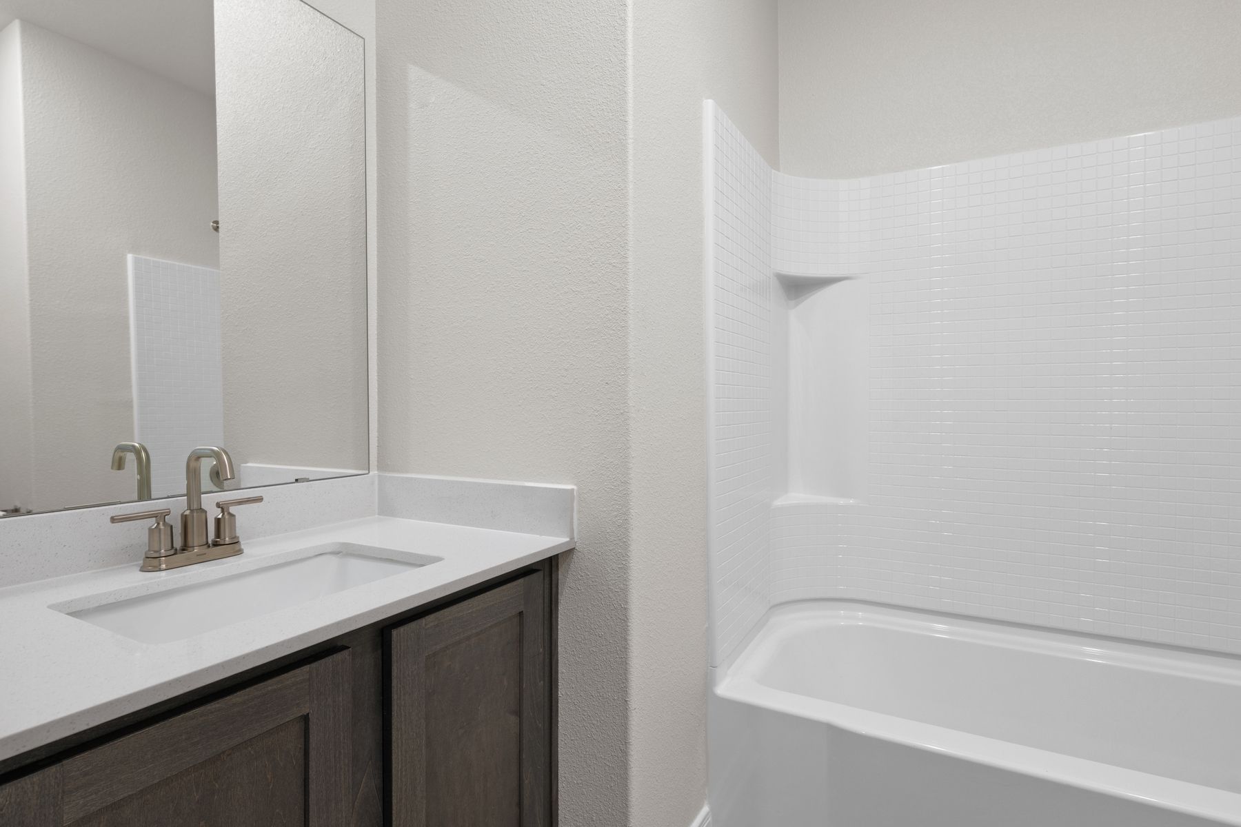 The secondary bathroom has a sprawling vanity and shower-tub combo.