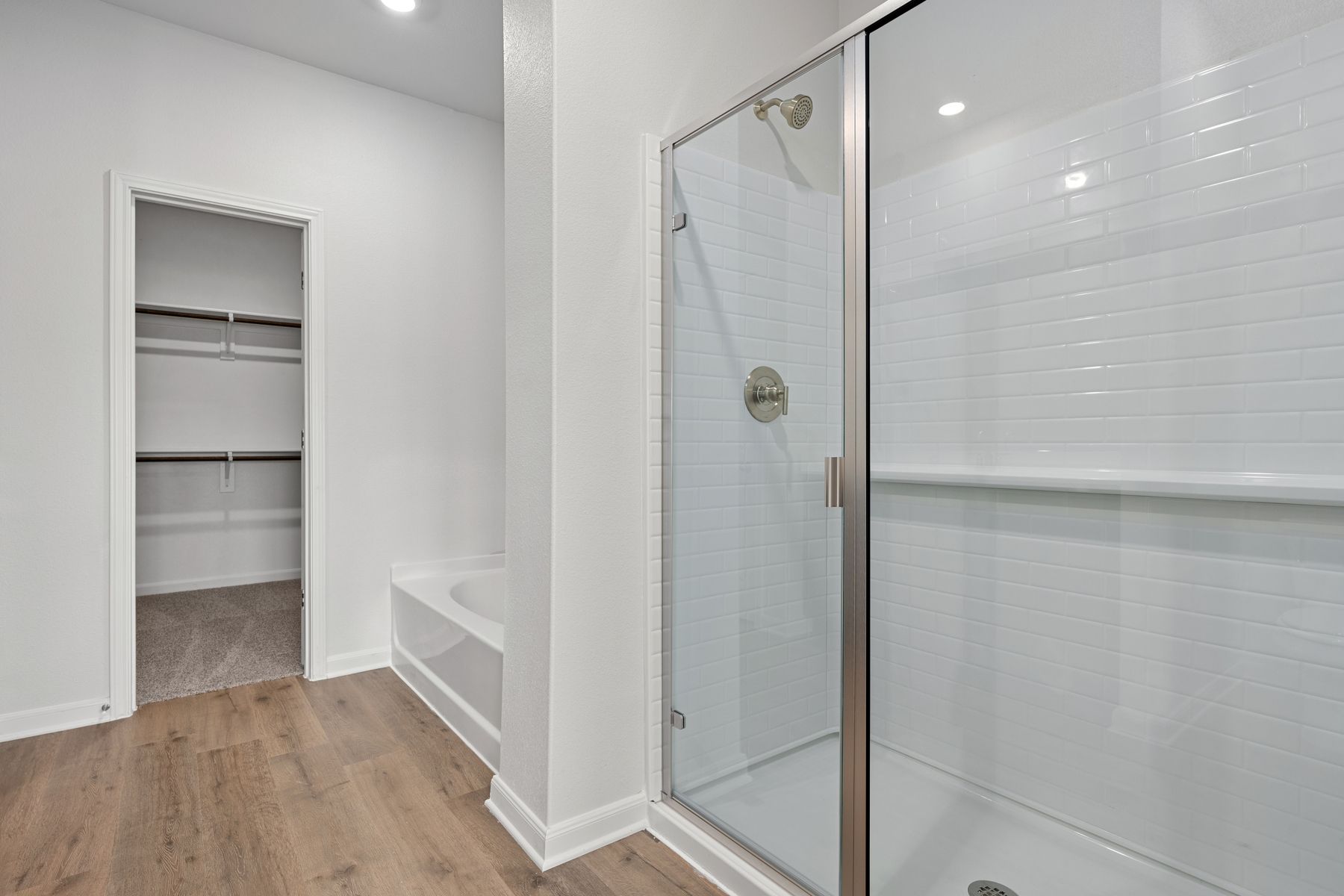 The master bathroom has a large garden tub and a glass, walk-in shower.