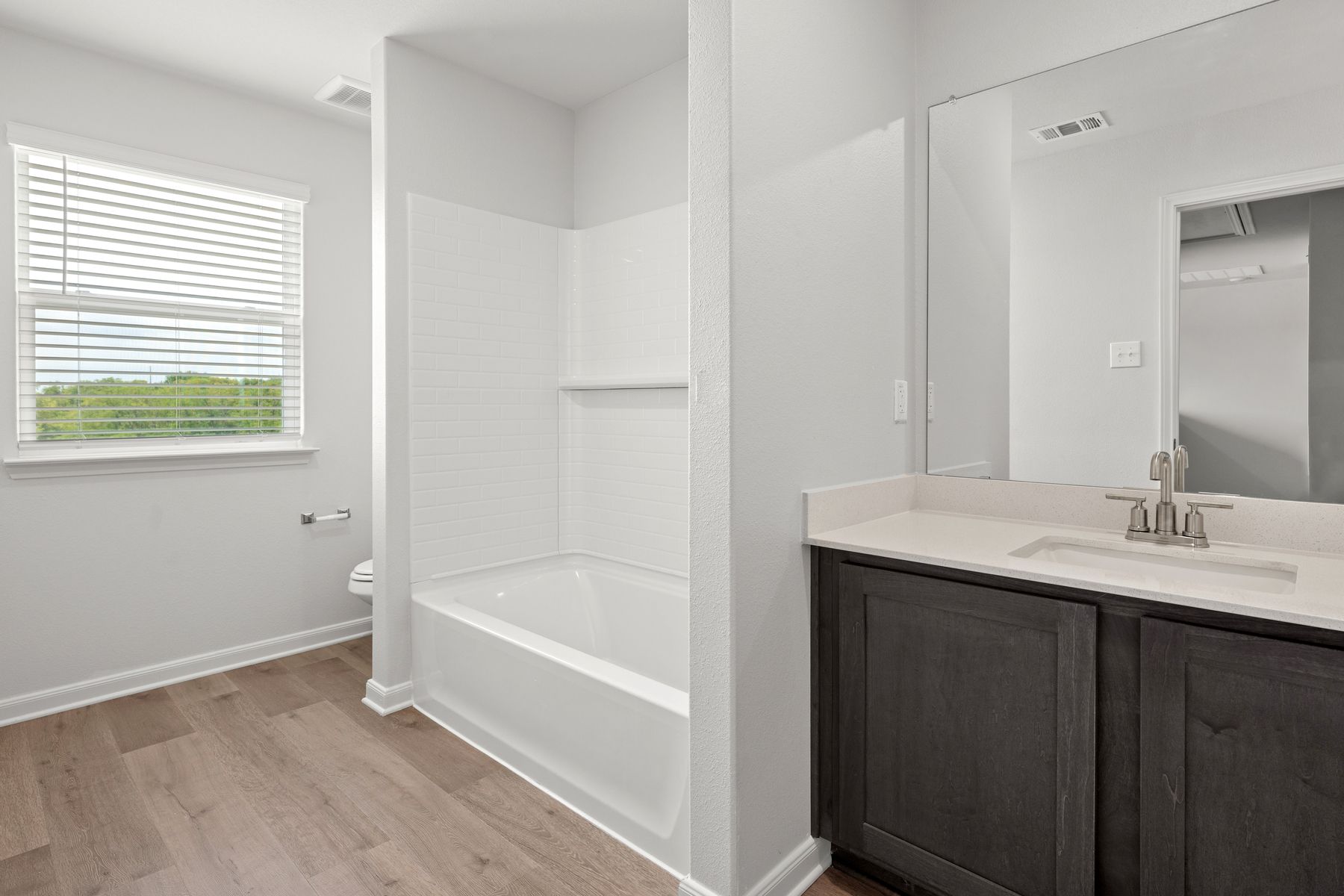 The secondary bathroom of the Cypress has a large vanity and shower-tub combo.