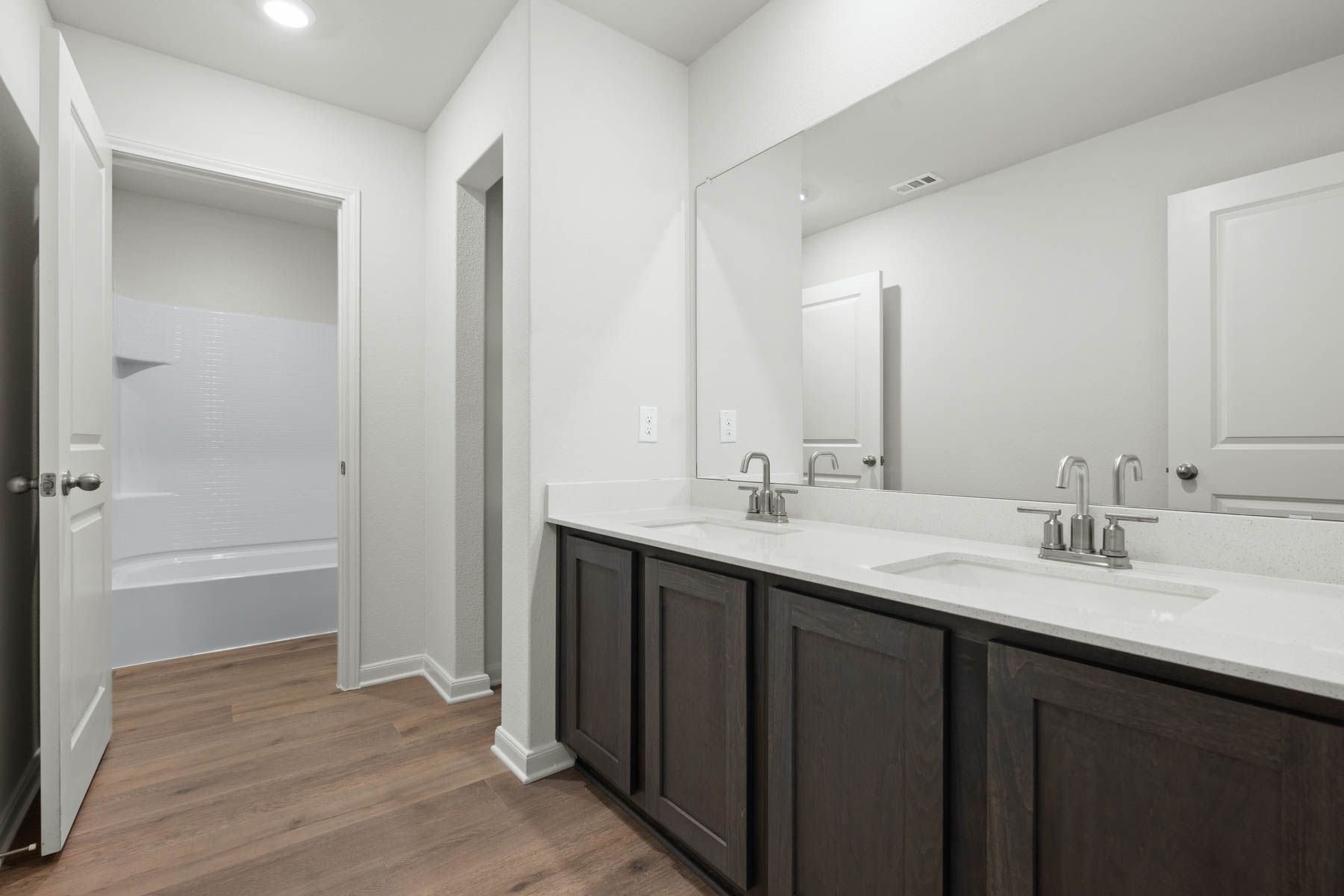 The secondary bathroom has a large vanity space and a shower-tub combo.
