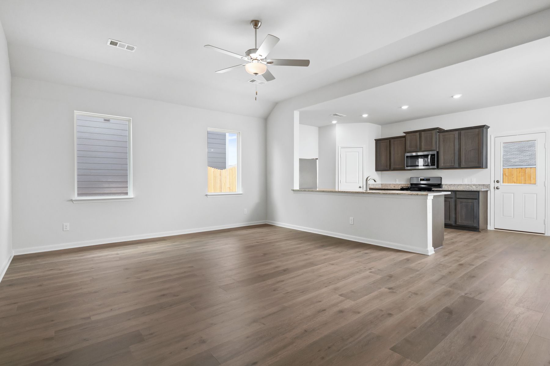 The kitchen, dining room and living room sit adjacent to one another.