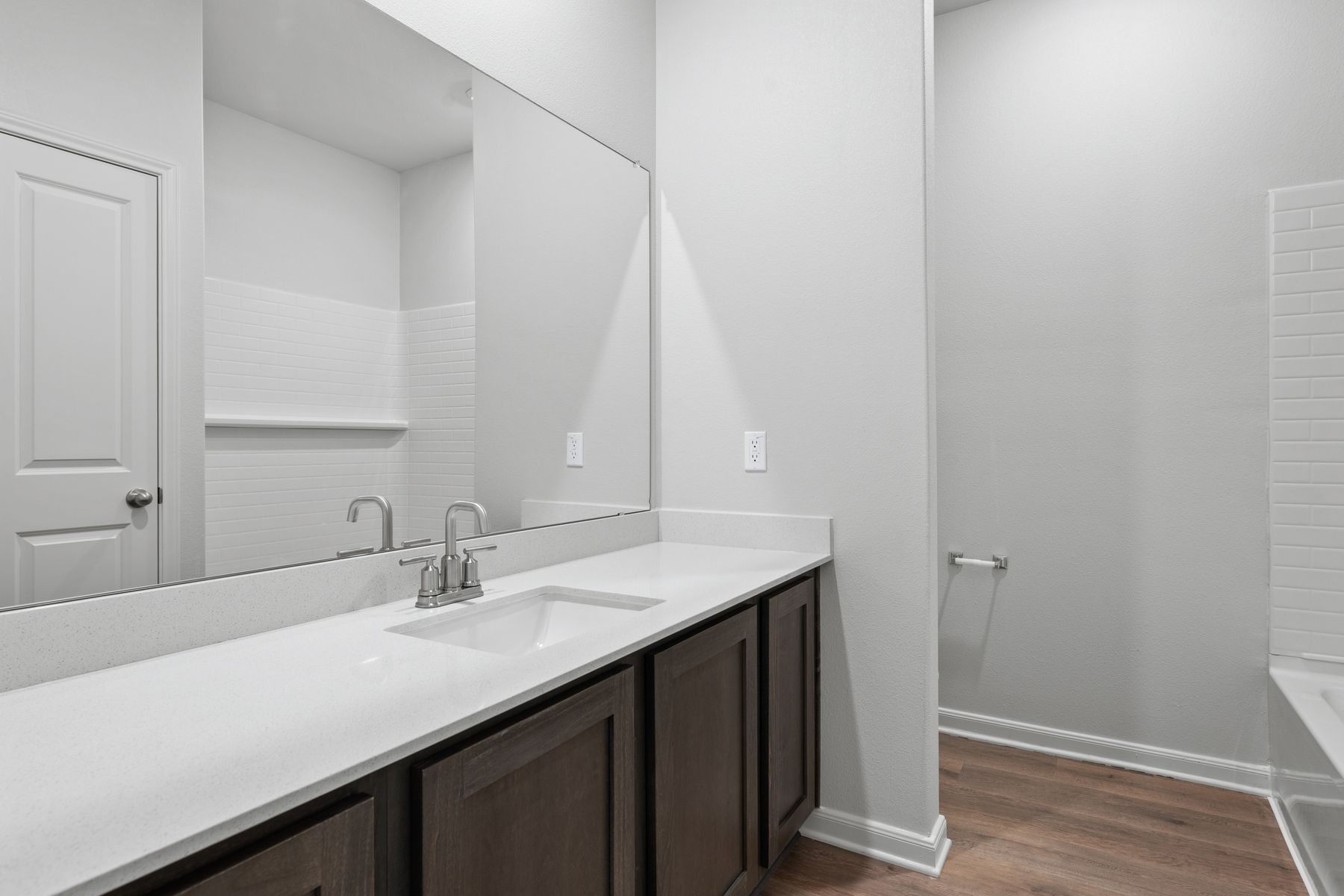 The secondary bathroom has a large vanity space and a shower-tub combo.