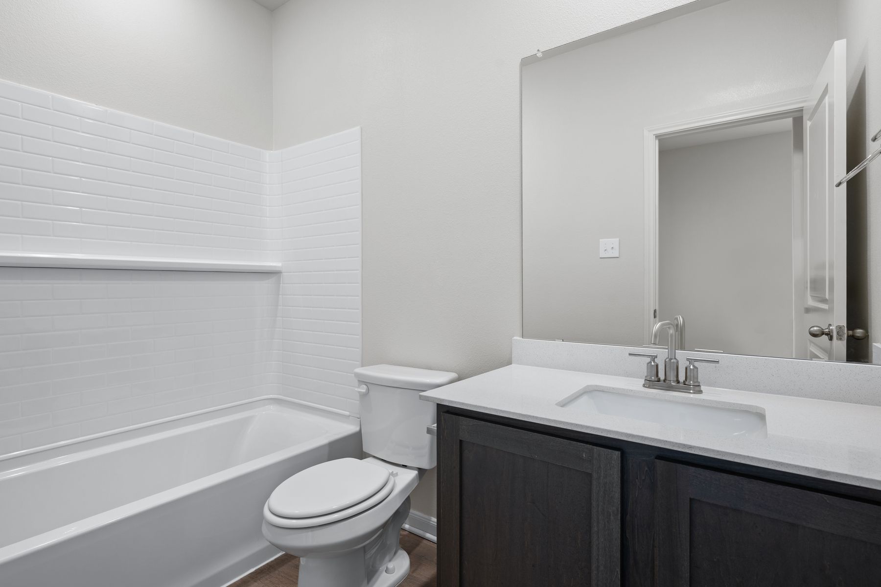 The secondary bathroom has a spacious vanity and shower-tub combo.
