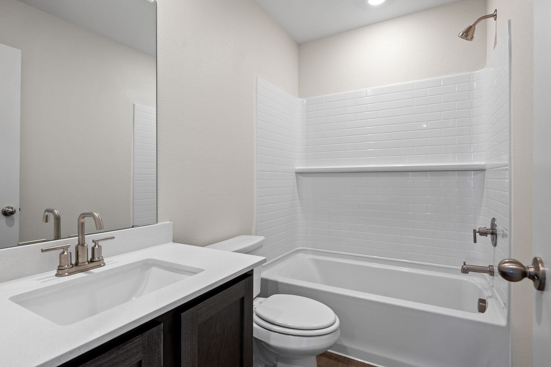 The secondary bathroom has a large vanity space and a shower-tub combo.