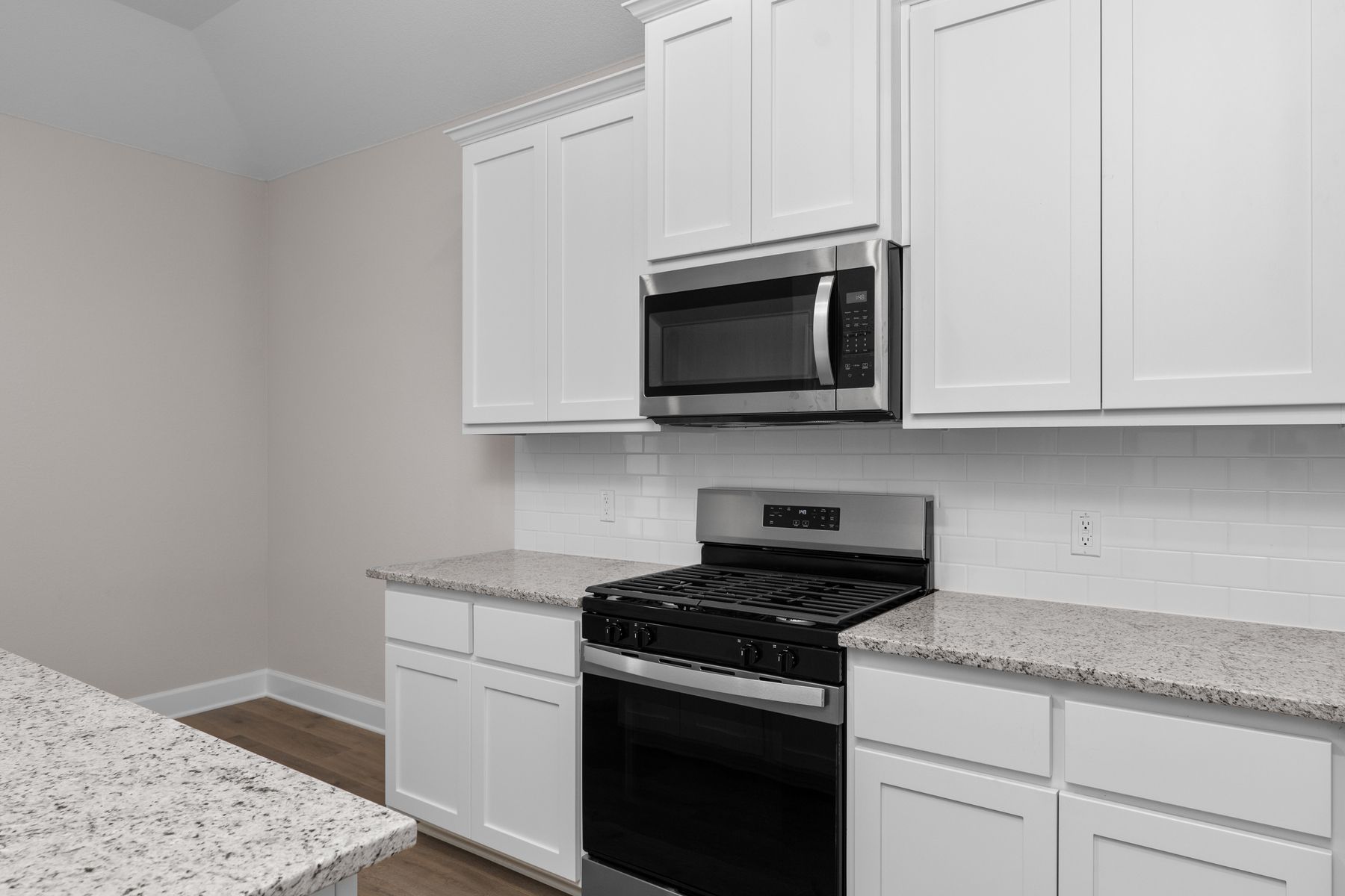 The kitchen has beautiful white wood cabinetry.