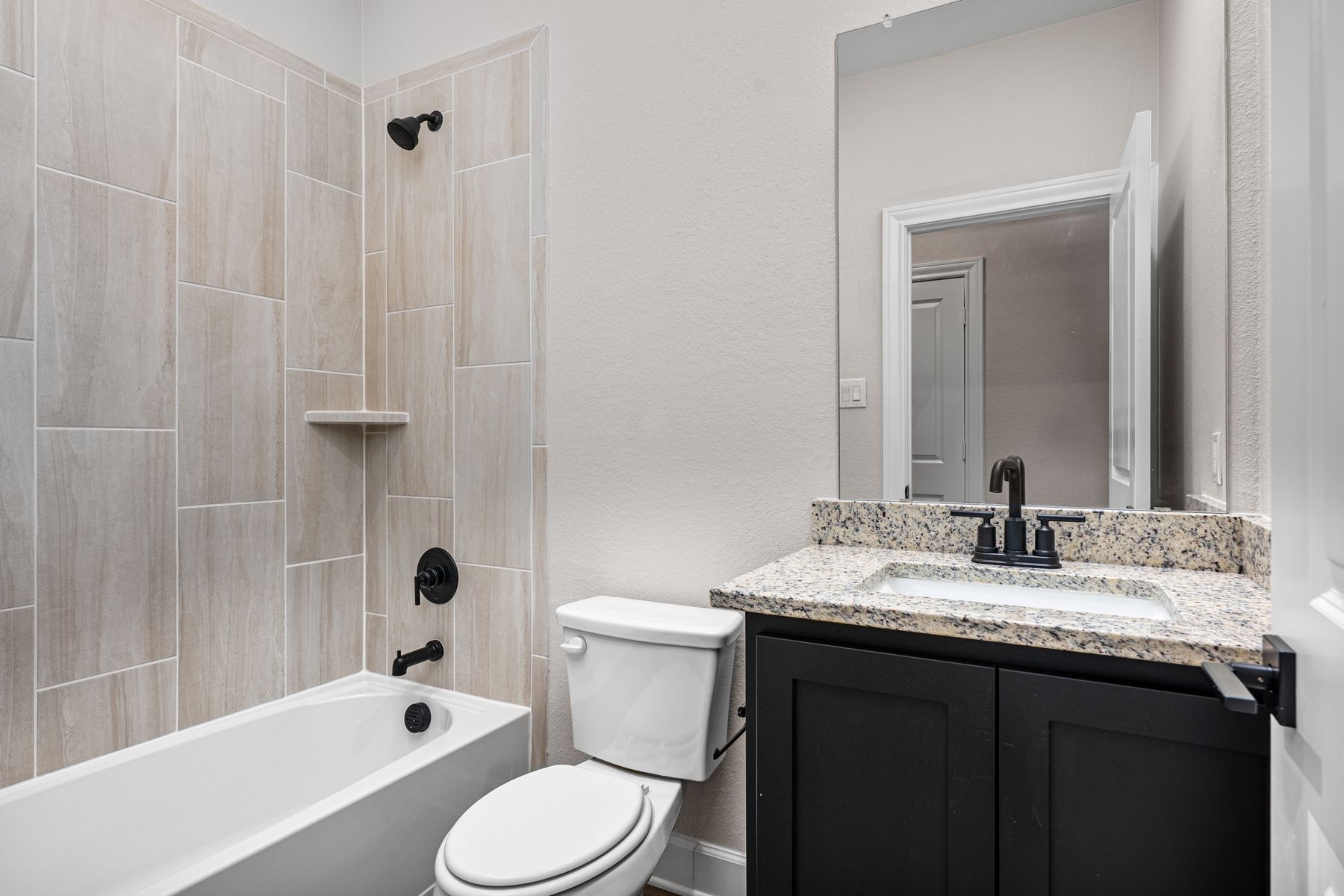 The secondary bathroom has a nice vanity and shower-tub combo.