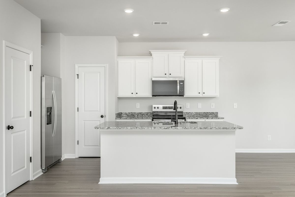 The kitchen has designer wood cabinetry