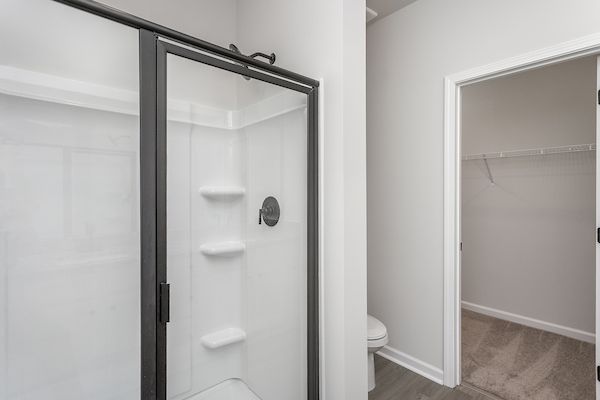 This bathroom has dual sinks and a glass-enclosed shower