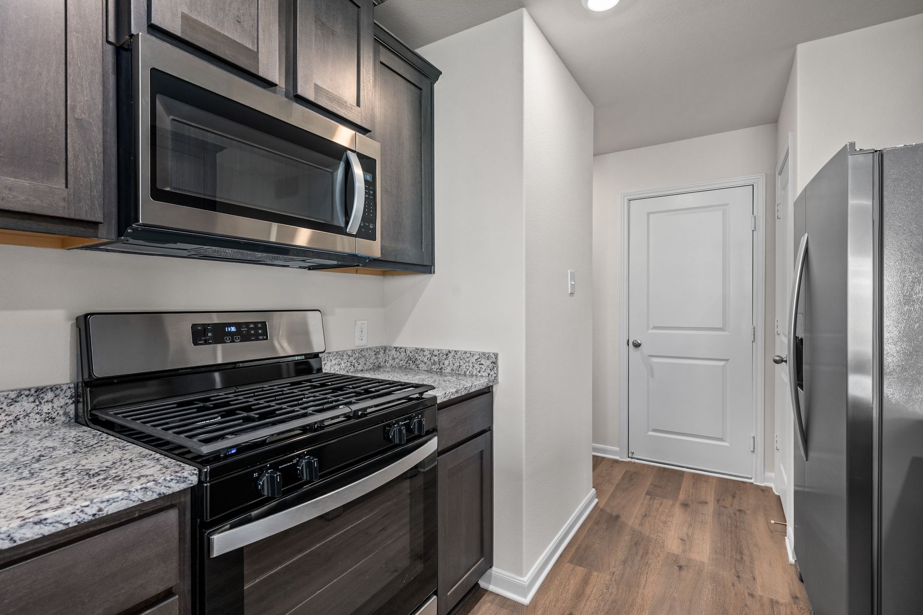 The kitchen has designer wood cabinetry.
