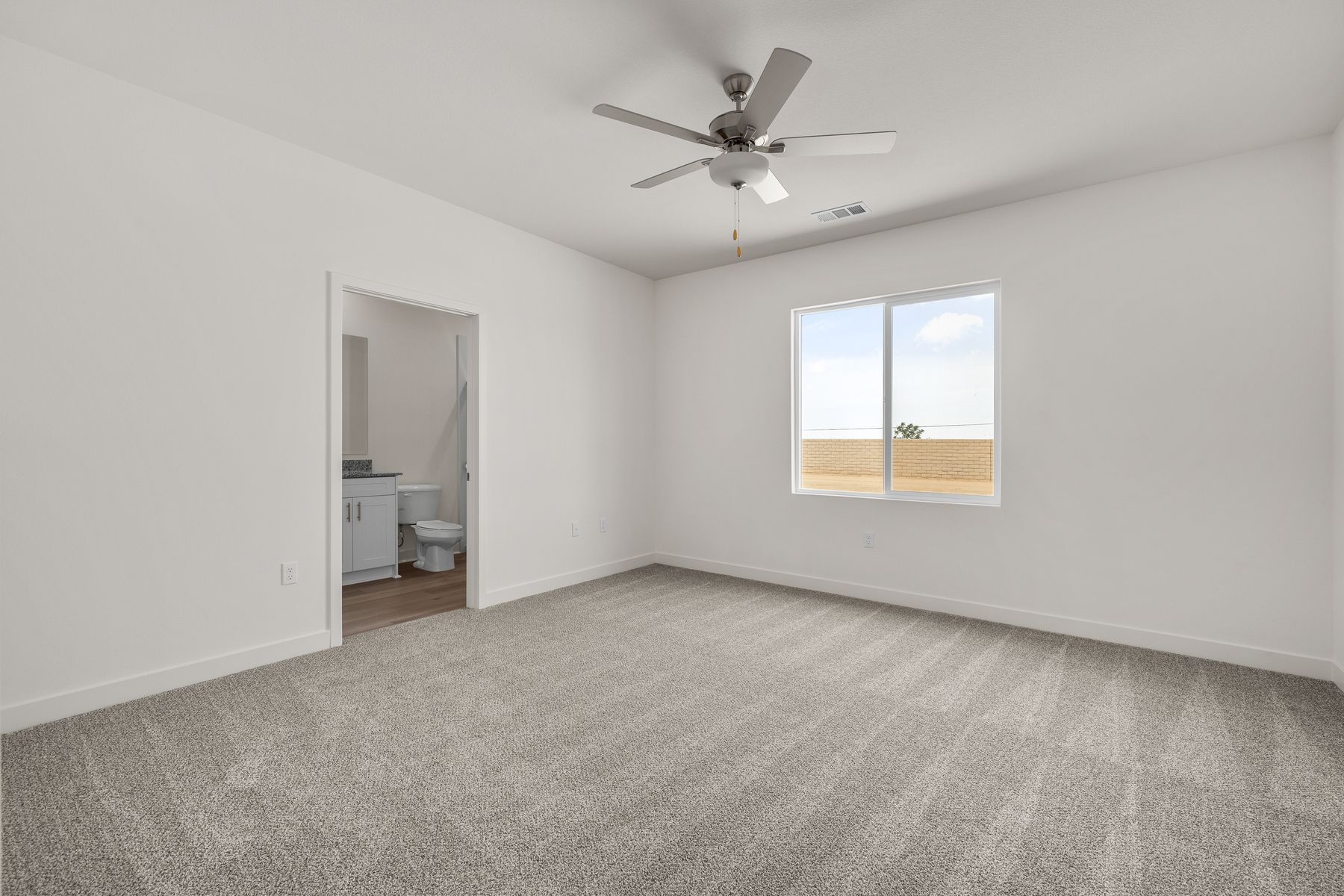 The master bedroom is spacious and has carpet.