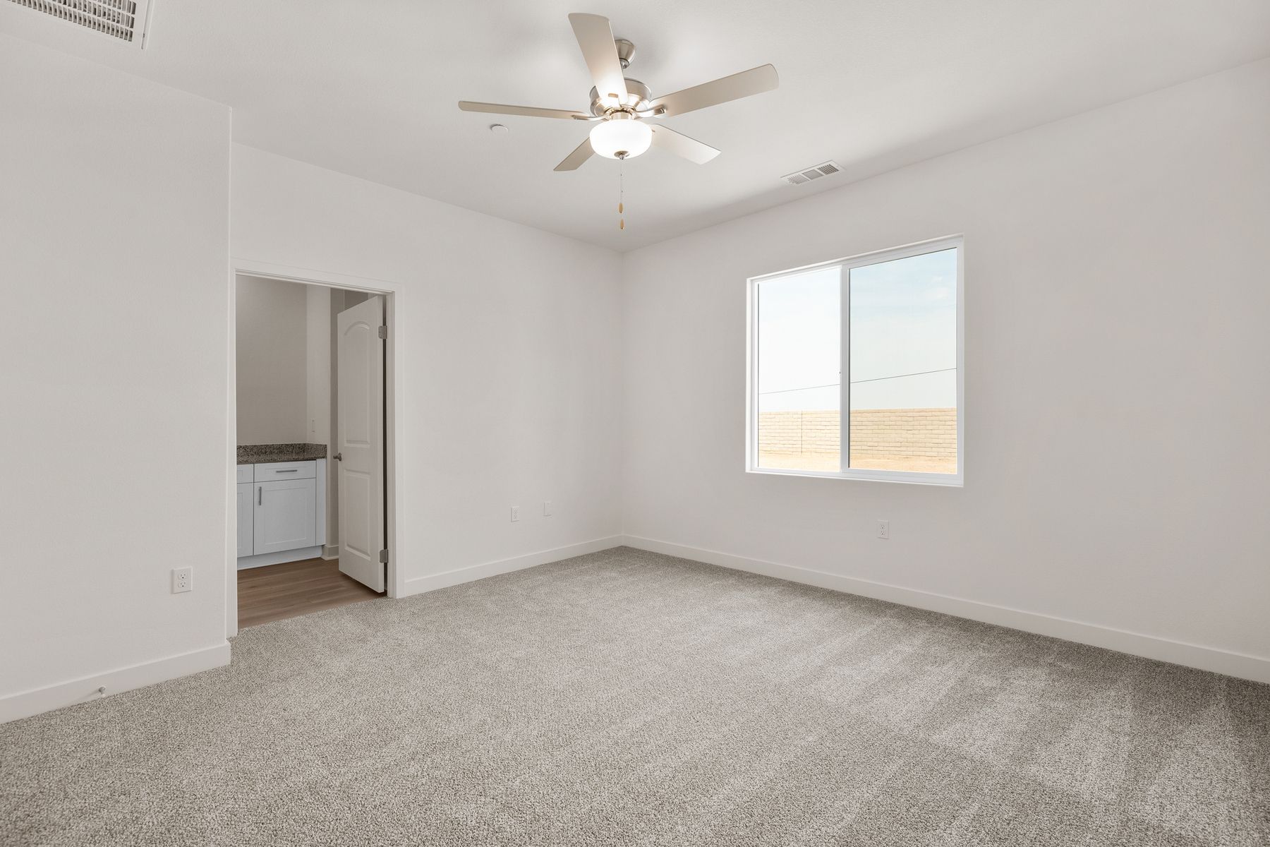 The master bedroom is spacious and has carpet.