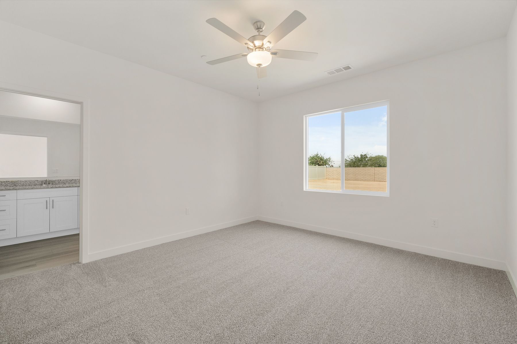 The master bedroom is spacious and has carpet.