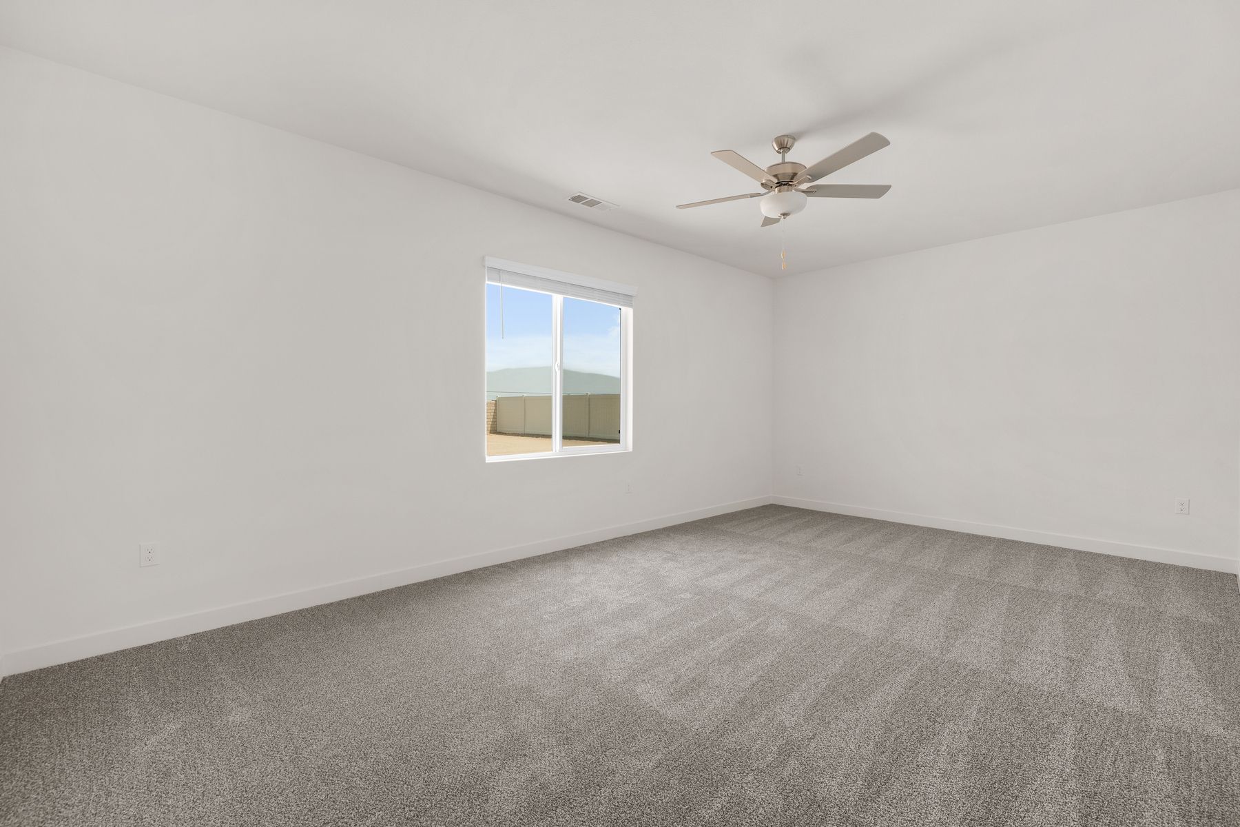 The master bedroom is spacious and has carpet.