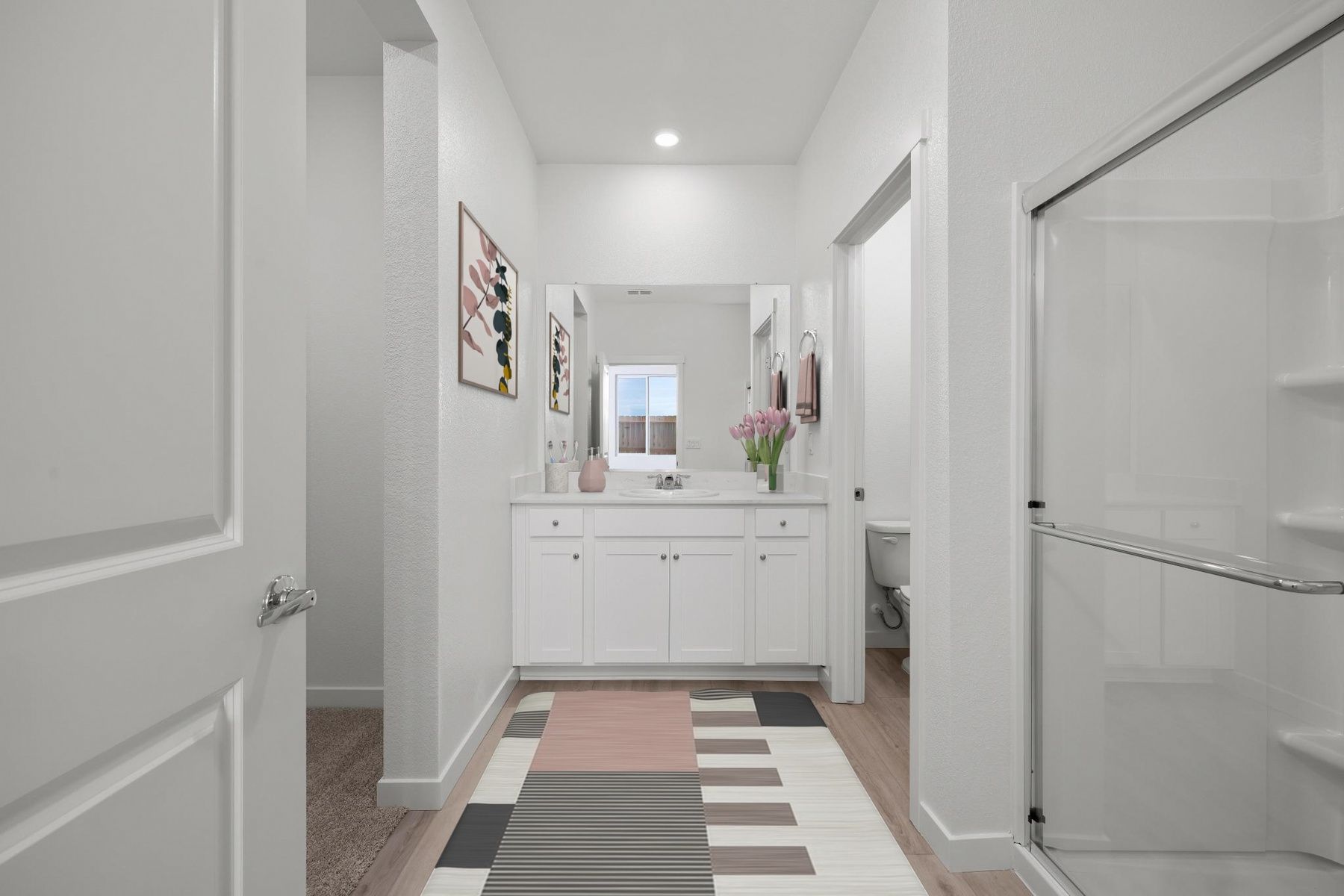 The master bathroom has a large vanity and a step in shower.