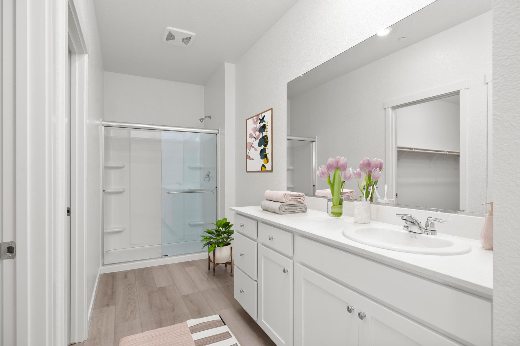 The master bathroom has a large vanity and a step in shower.