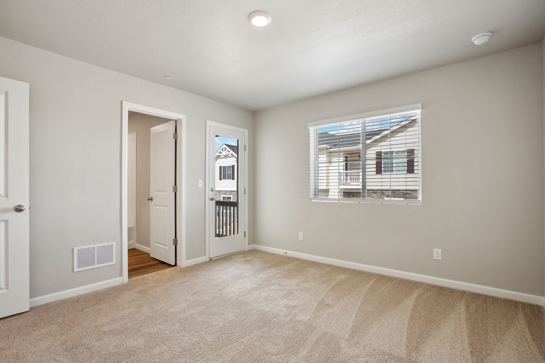 The master bedroom is spacious and has carpet.