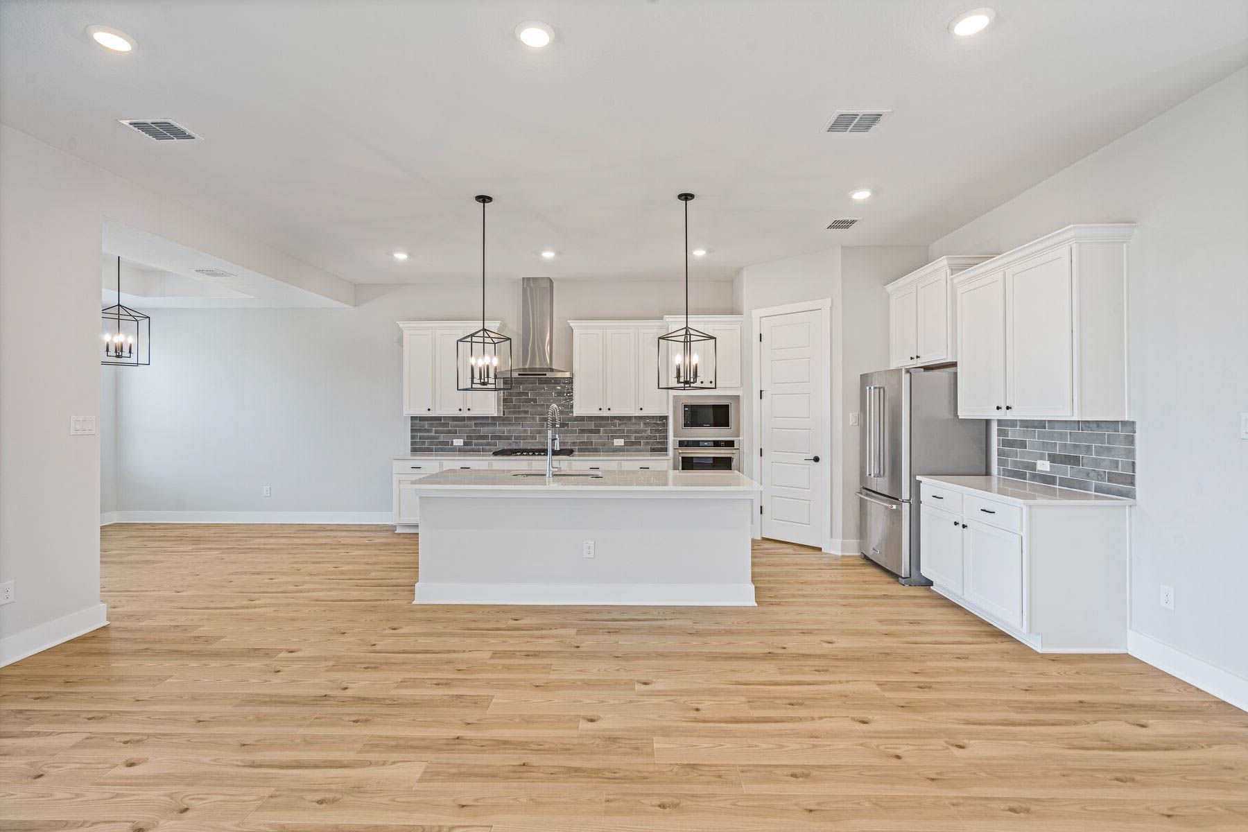 The kitchen has beautiful white wood cabinetry.