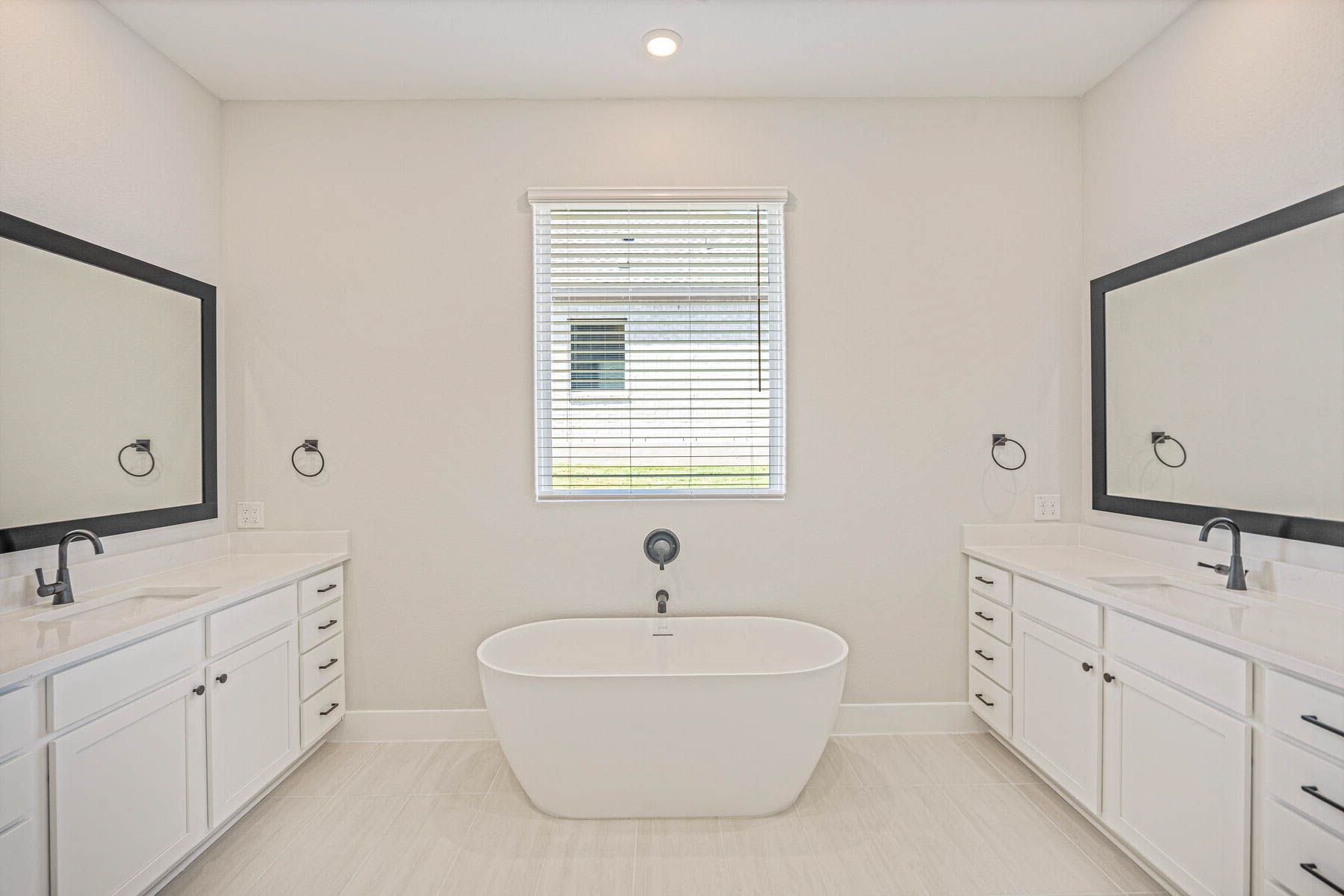 The master bathroom has two sprawling vanities and a stand-alone tub.