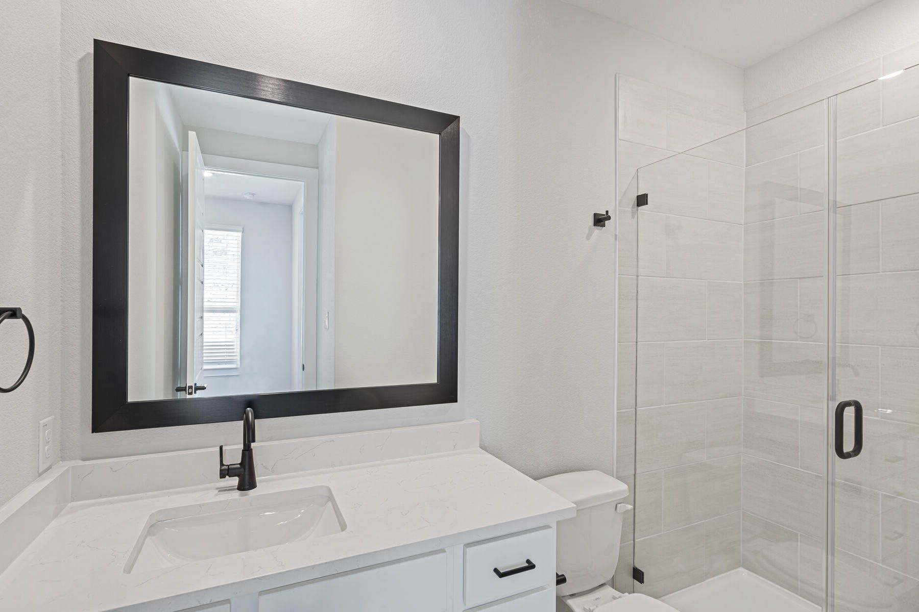 The third full bathroom has a vanity and glass, walk-in shower.