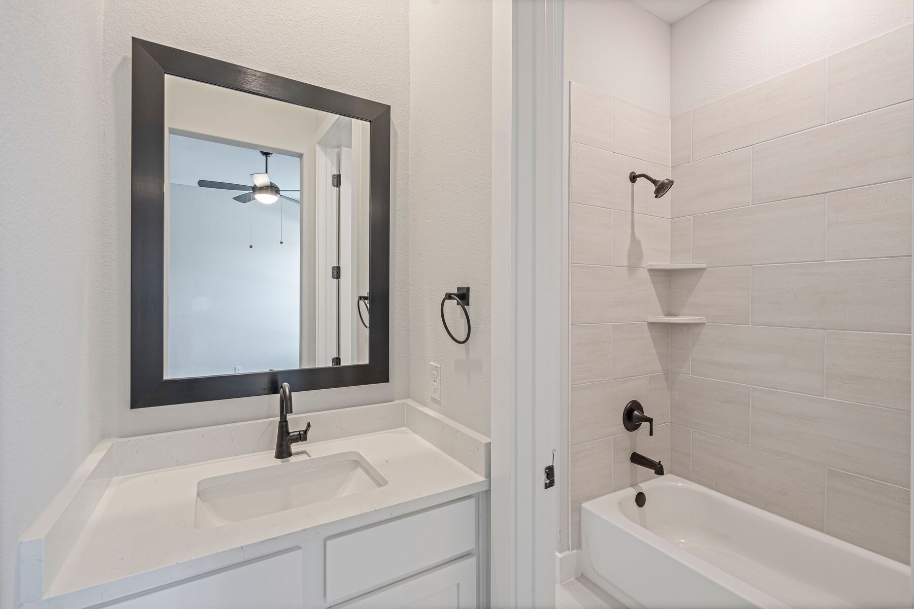 The Jack-and-Jill bathroom has a tiled shower-tub combo and toilet.