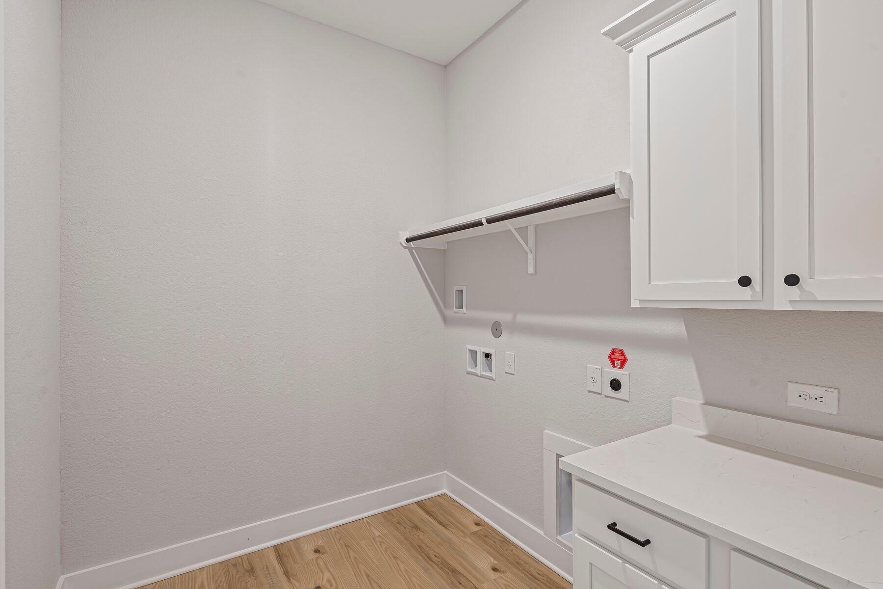 The laundry room has hanging space and cabinet space.