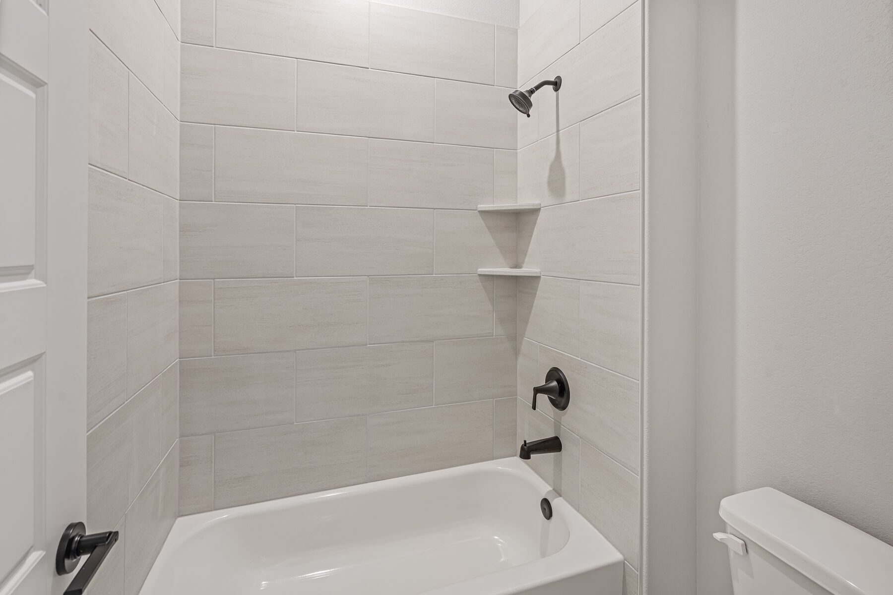 The secondary bathroom has a tiled shower-tub combo.