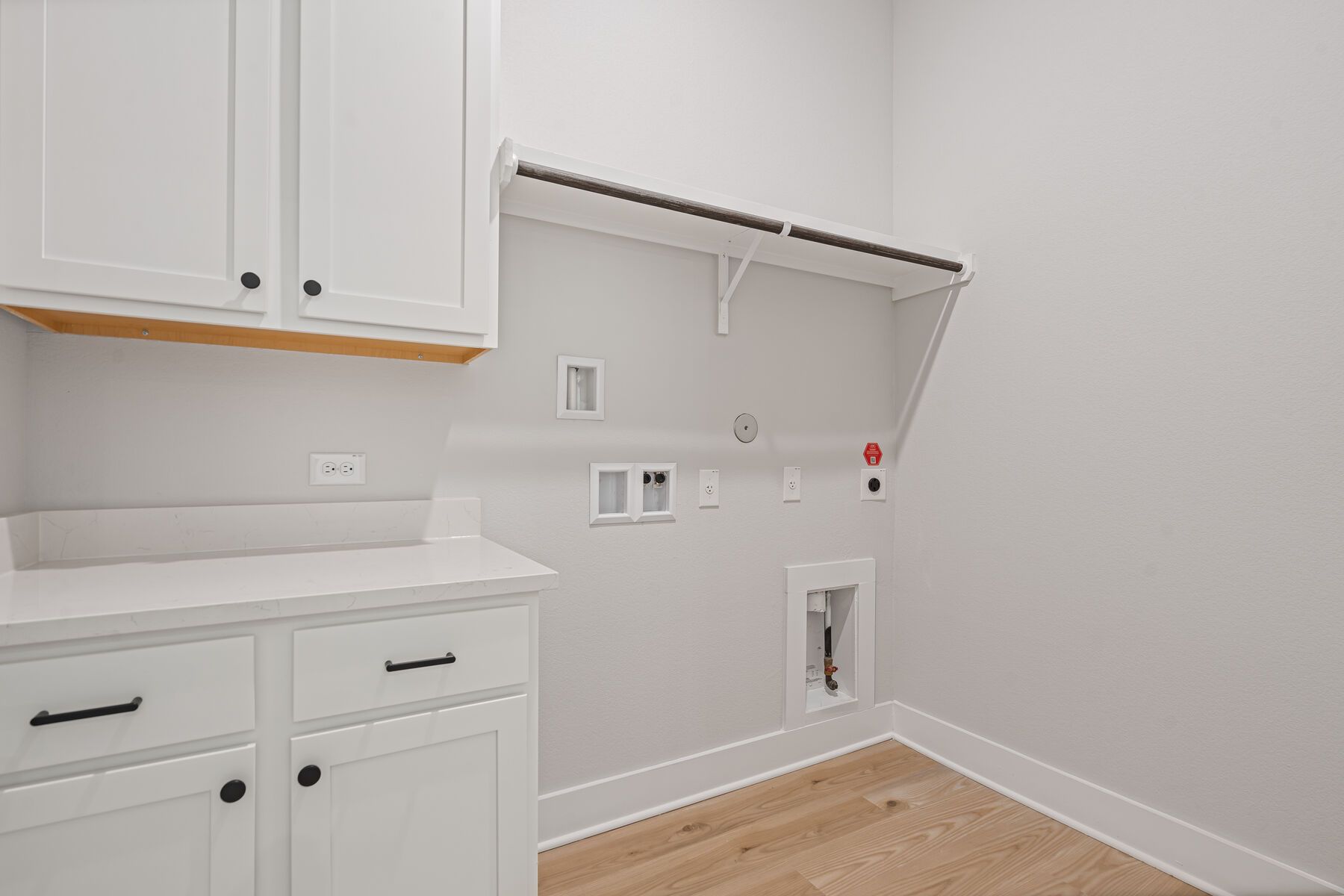 The laundry room has hanging space and cabinet space.