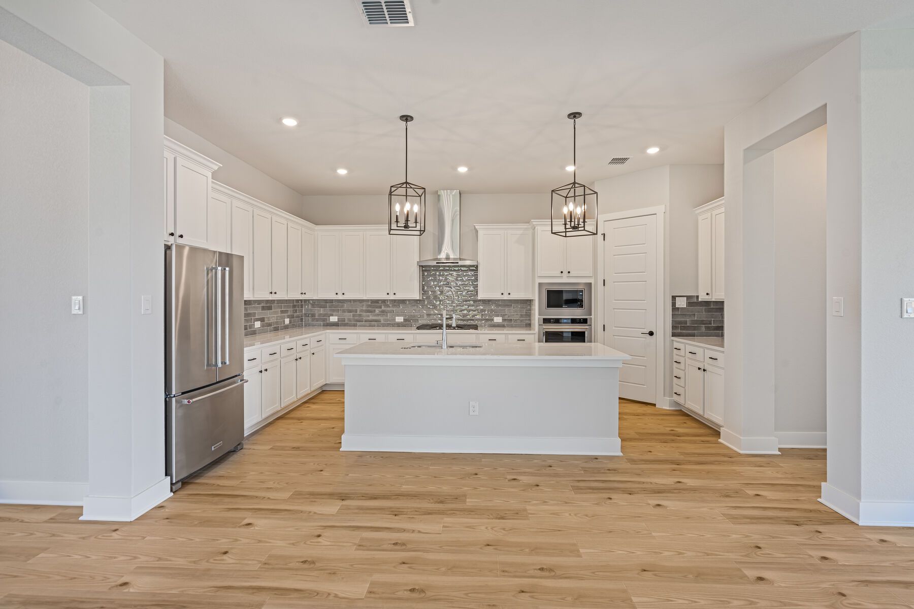 The kitchen has beautiful white wood cabinetry.