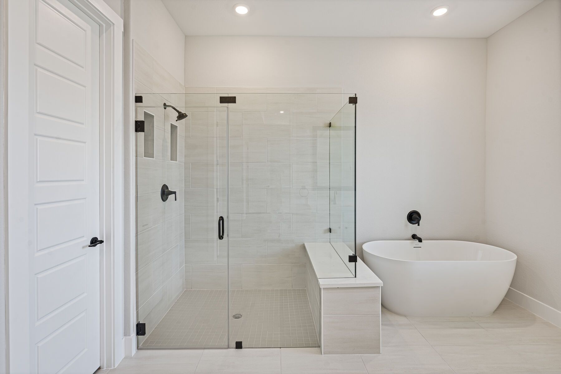 The master bathroom has a large stand-alone tub and walk-in, glass shower.