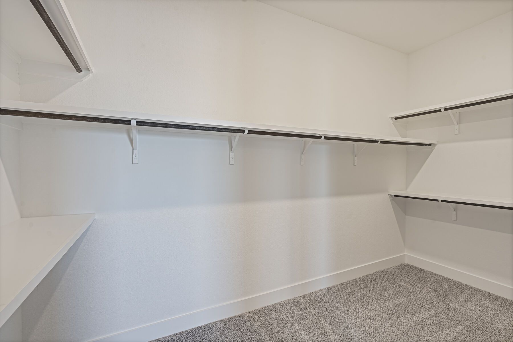 The master closet is spacious with lots of shelves and hanging space.