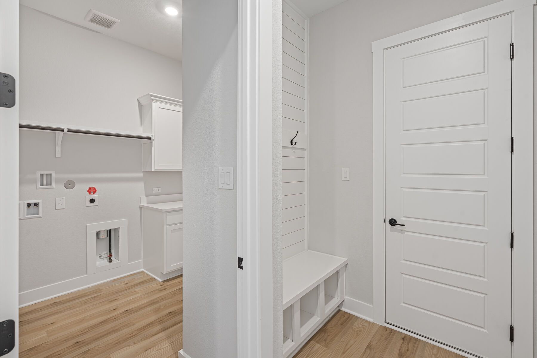 The mudroom has a built-in bench and hooks right next to the garage door.