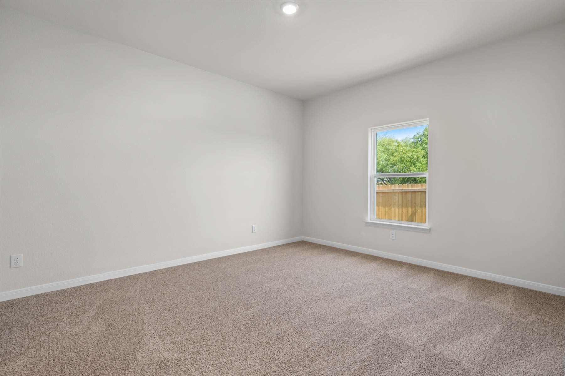 The master bedroom is spacious and has a large window.