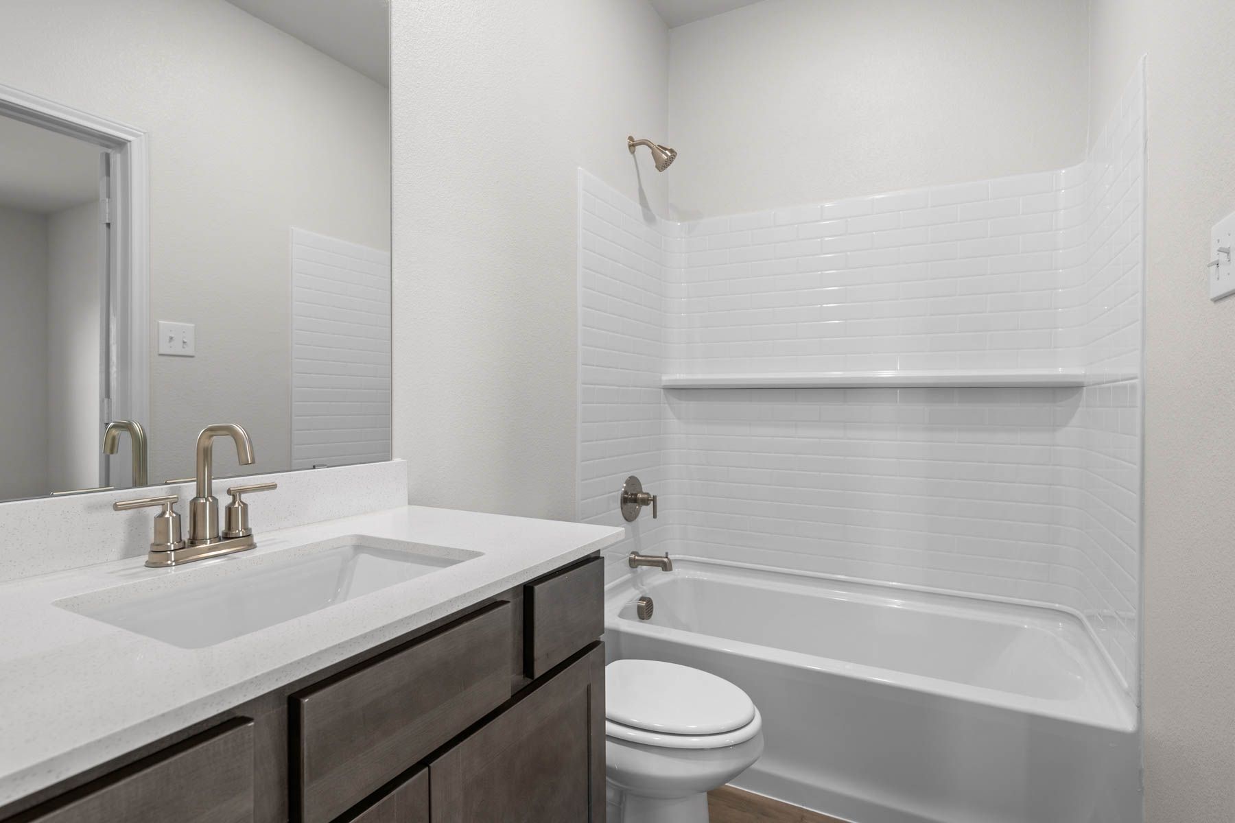 The master bathroom has a sprawling vanity and shower-tub combo.