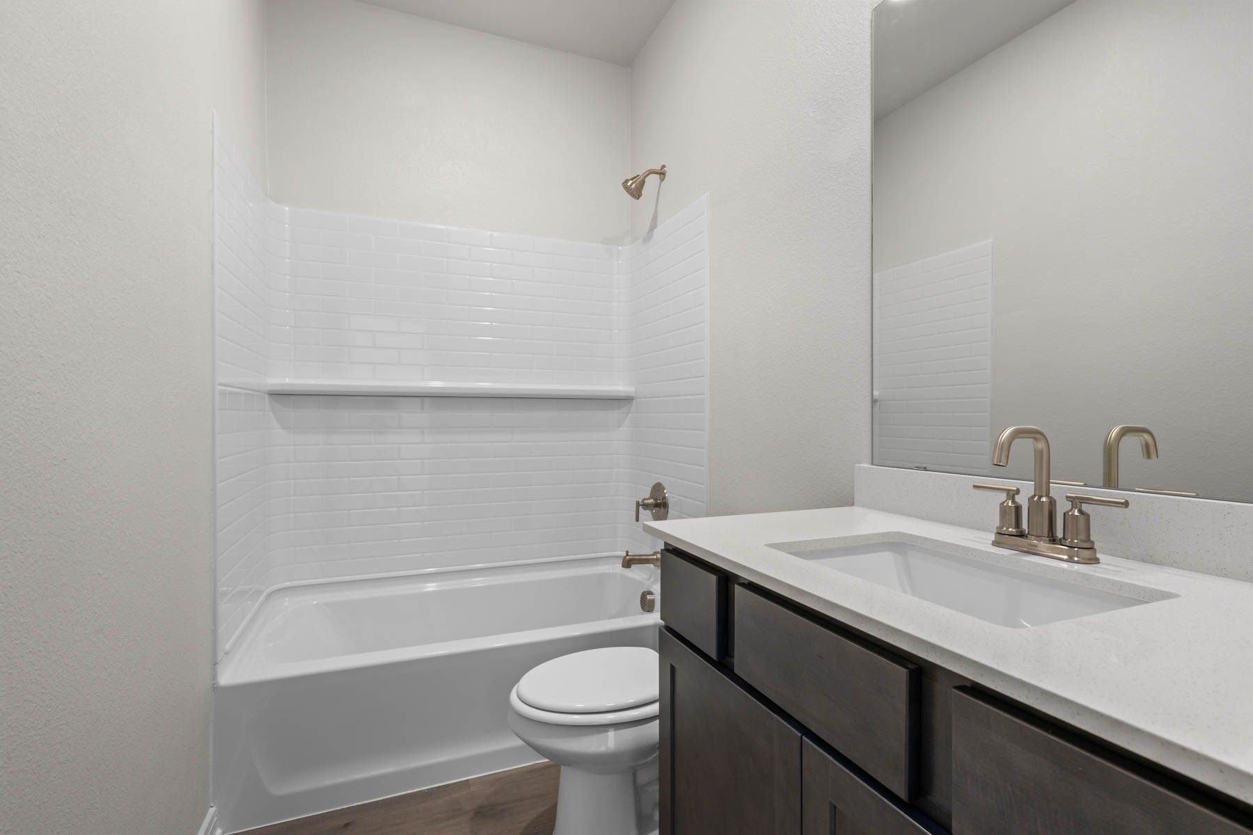 The secondary bathroom has a sprawling vanity and shower-tub combo.