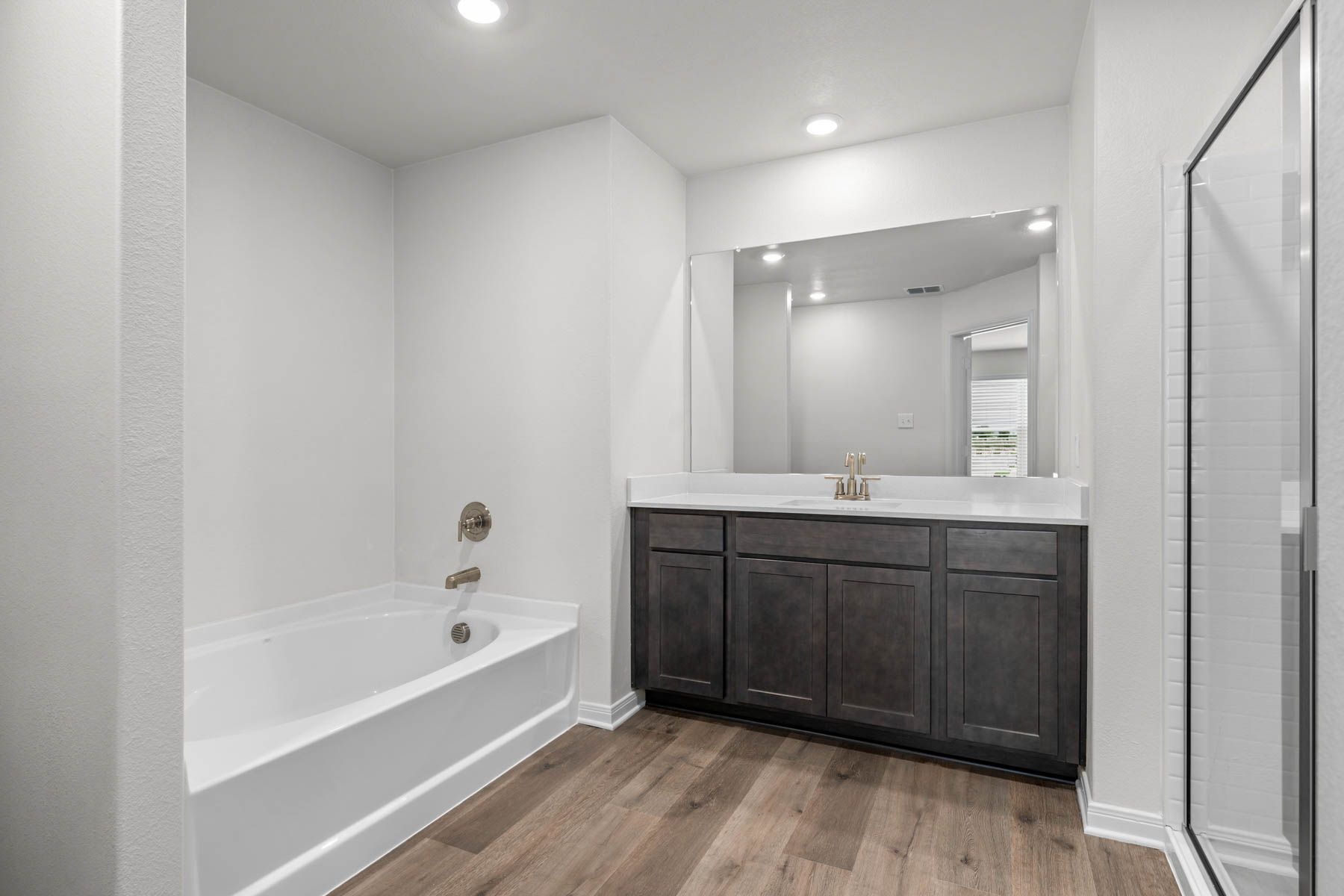 The master bathroom has a sprawling vanity, walk-in shower and a garden tub.