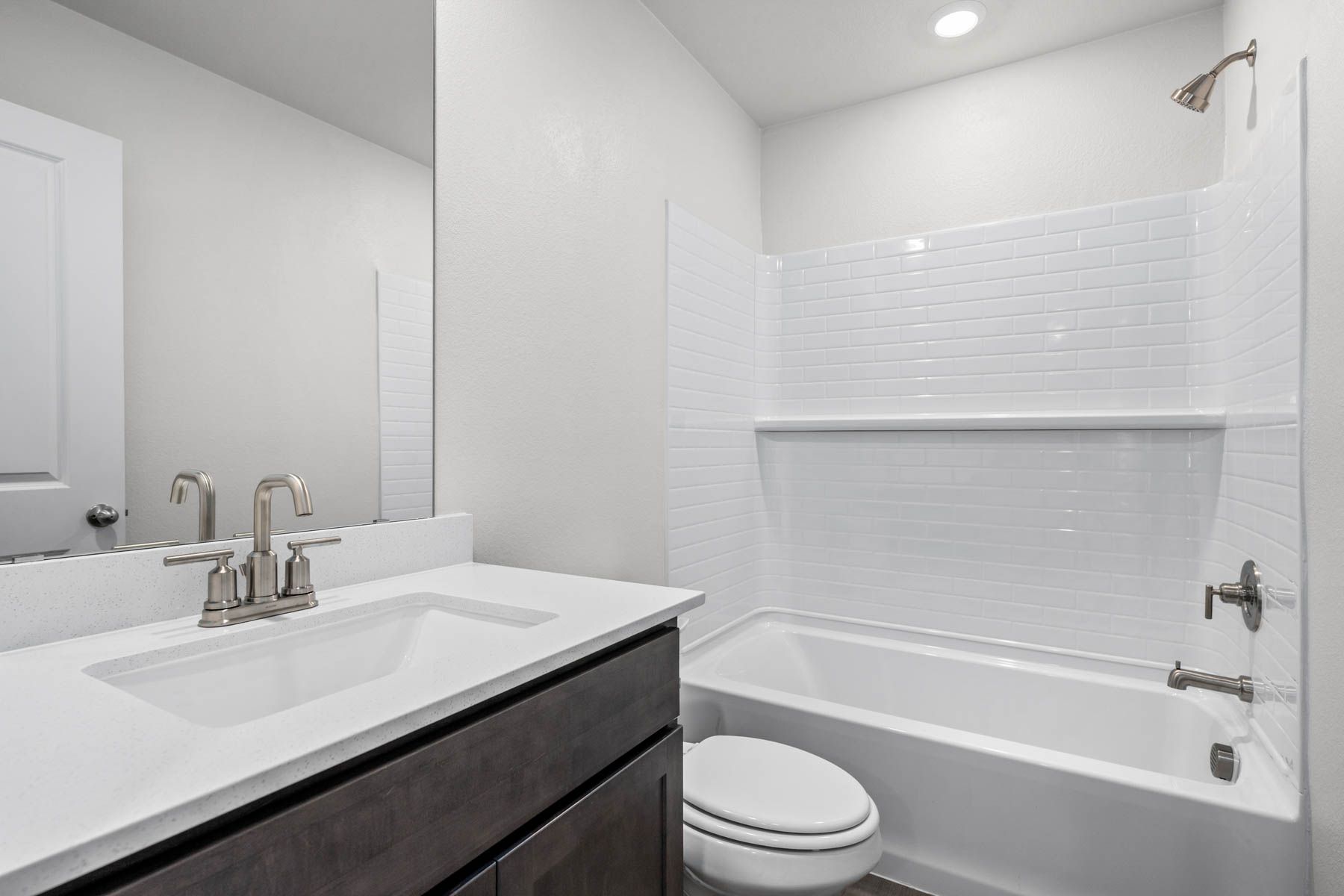 The secondary bathroom has a sprawling vanity and shower-tub combo.