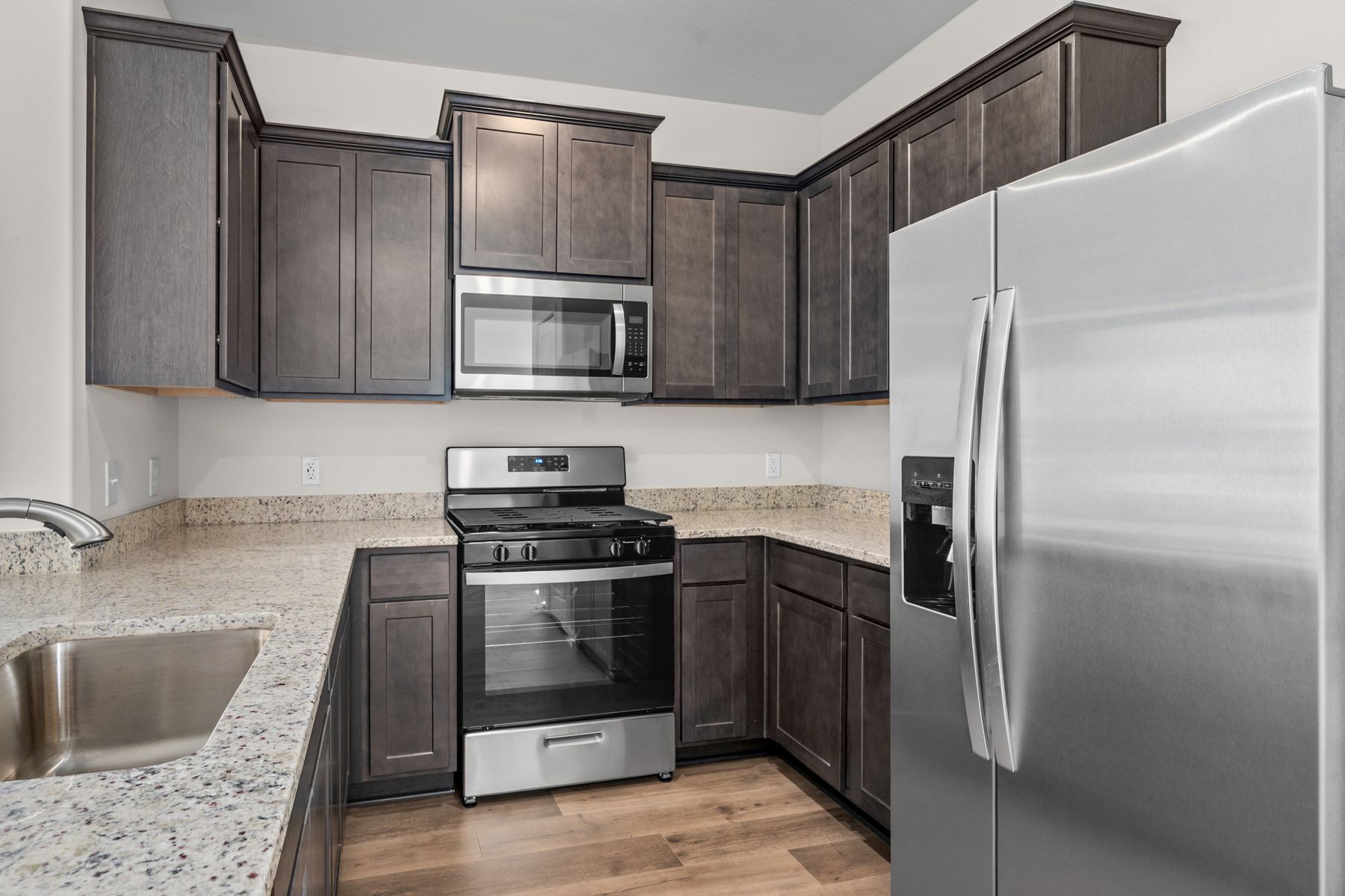 The kitchen has designer wood cabinetry.