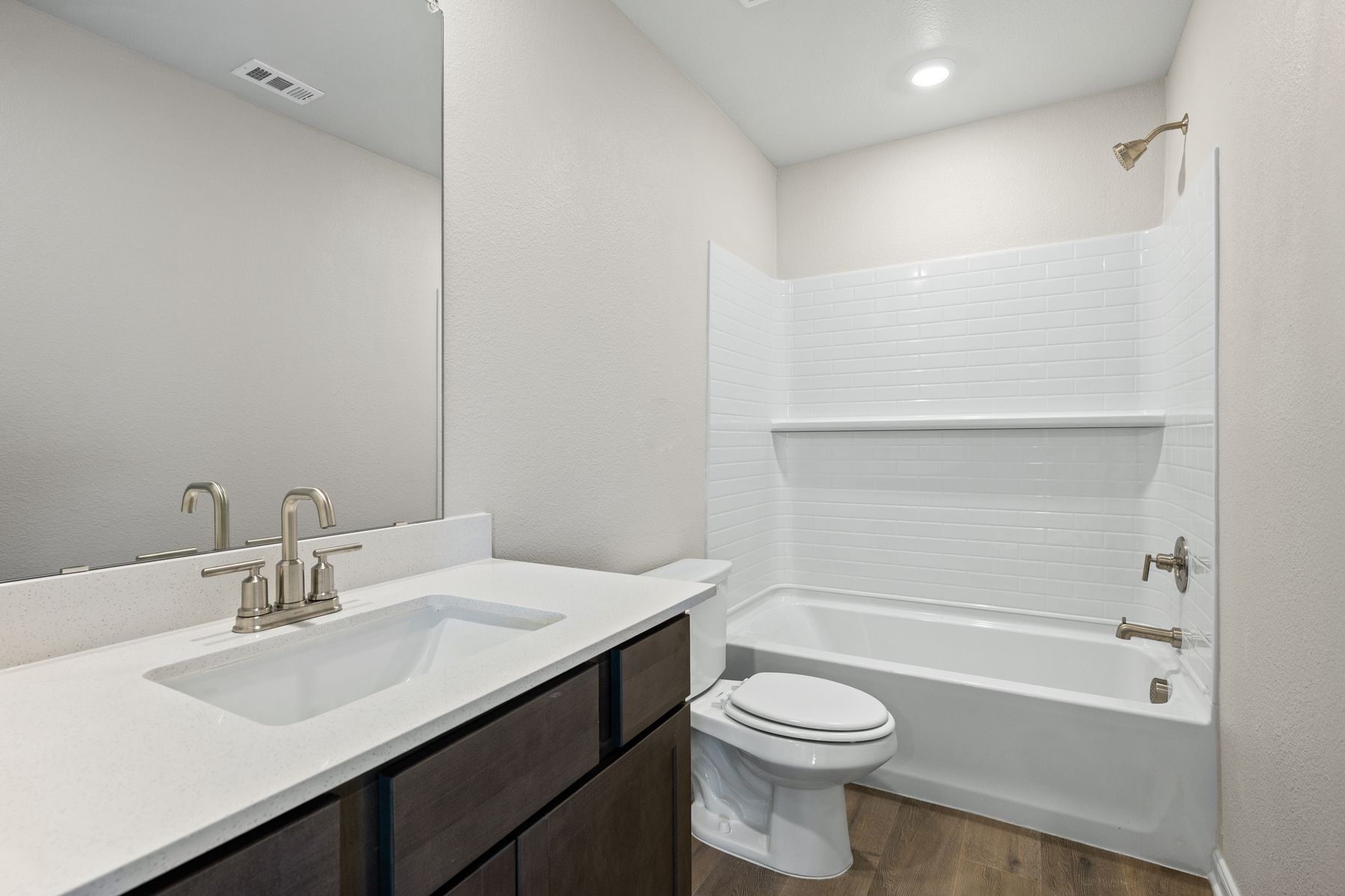 The secondary bathroom has a vanity space and a shower-tub combo.