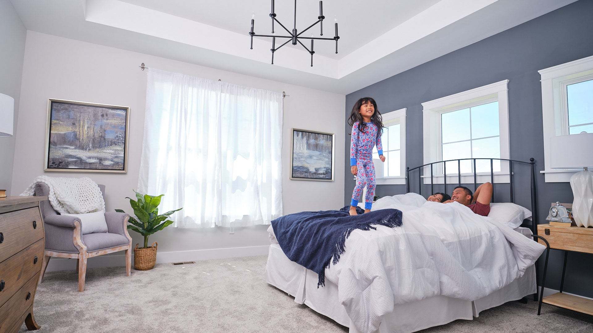 Daughter Jumping on Bed in New Primary Suite by Landmark Homes