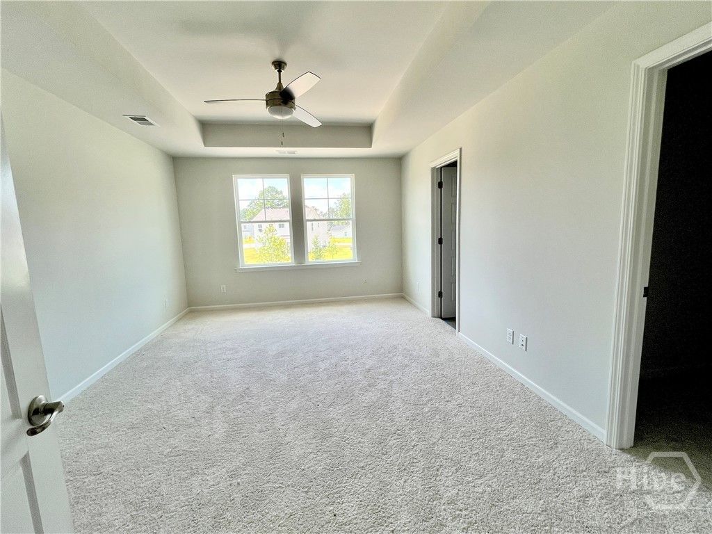 Primary bedroom. Notice the tray ceiling and inclu