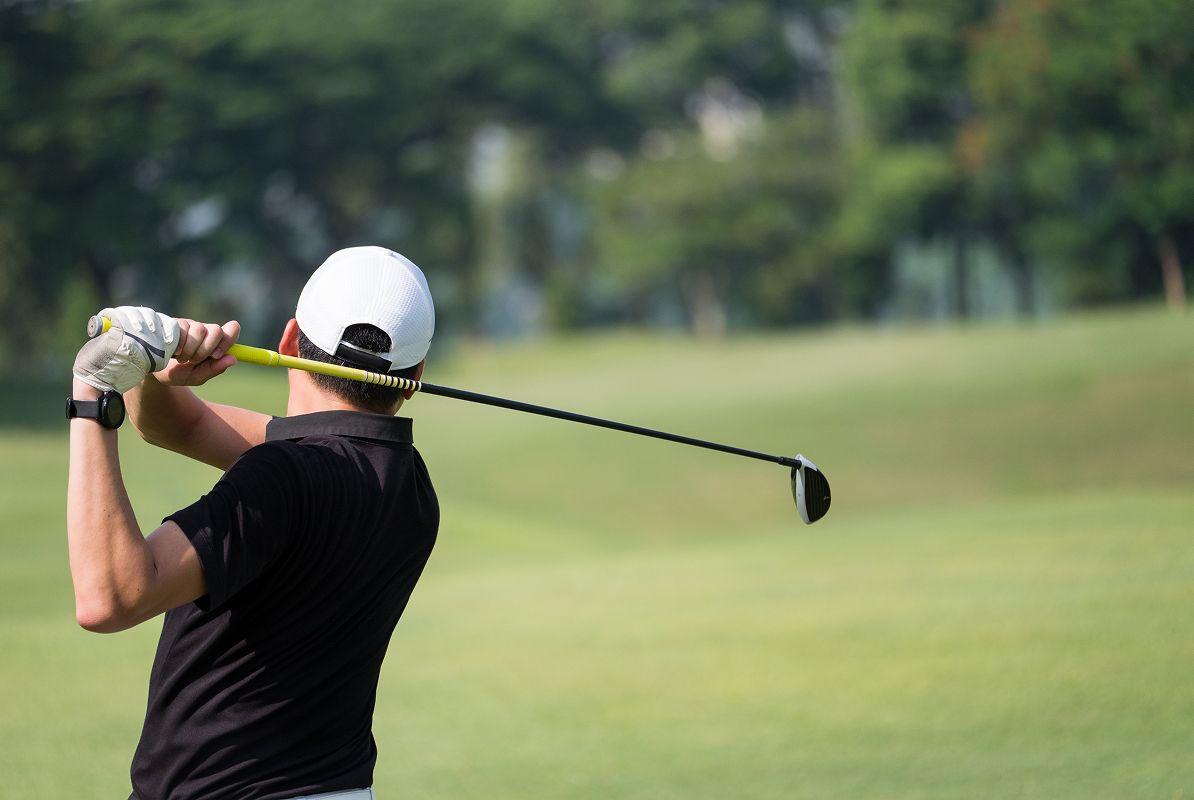 Man Swinging Golf Club
