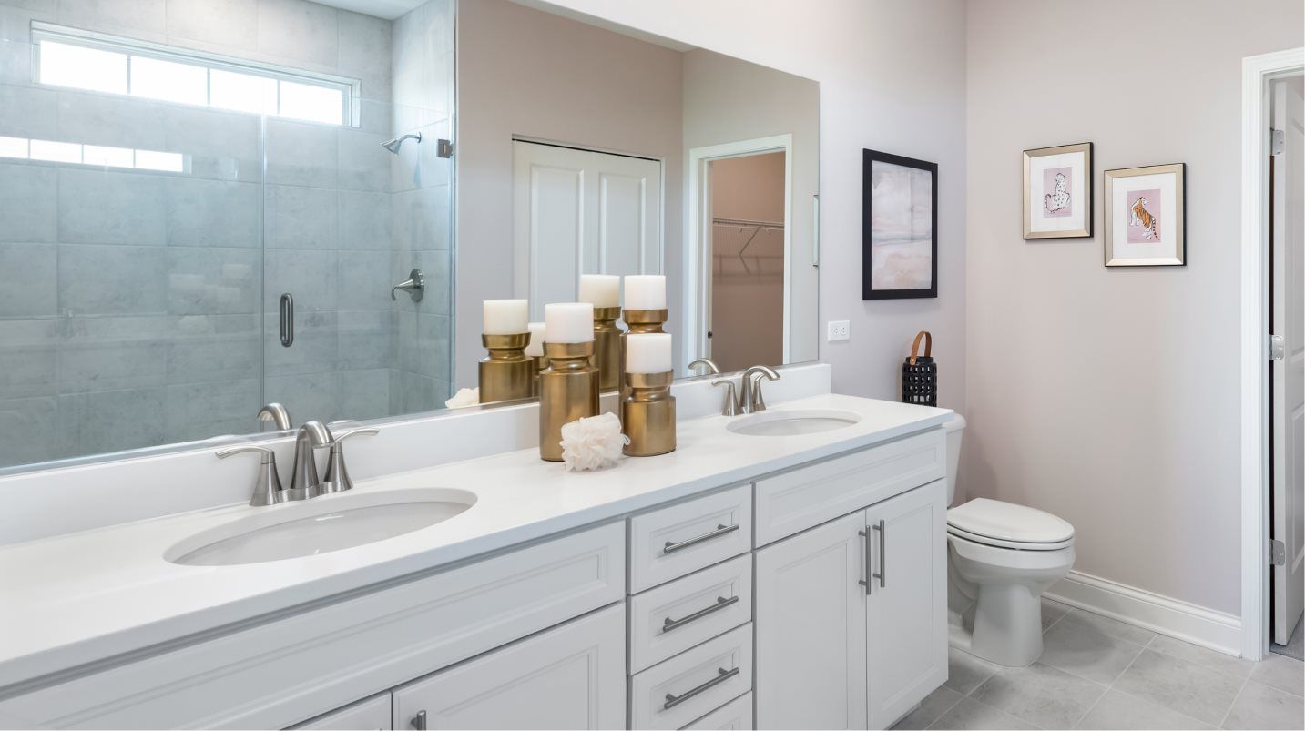 Spacious vanity with quartz countertops and Moen® brushed nickel faucets in the owner’s suite bathro