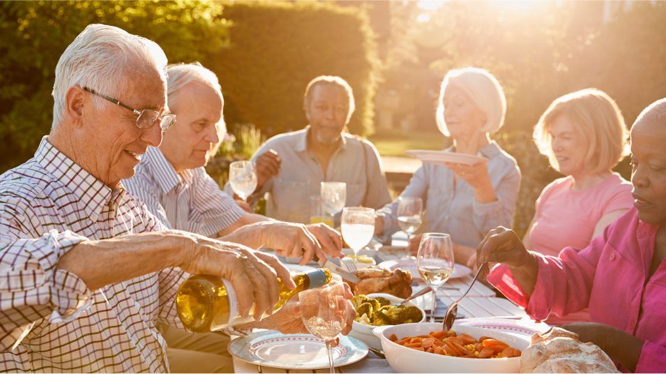 Active Adult group dining outdoors sunset