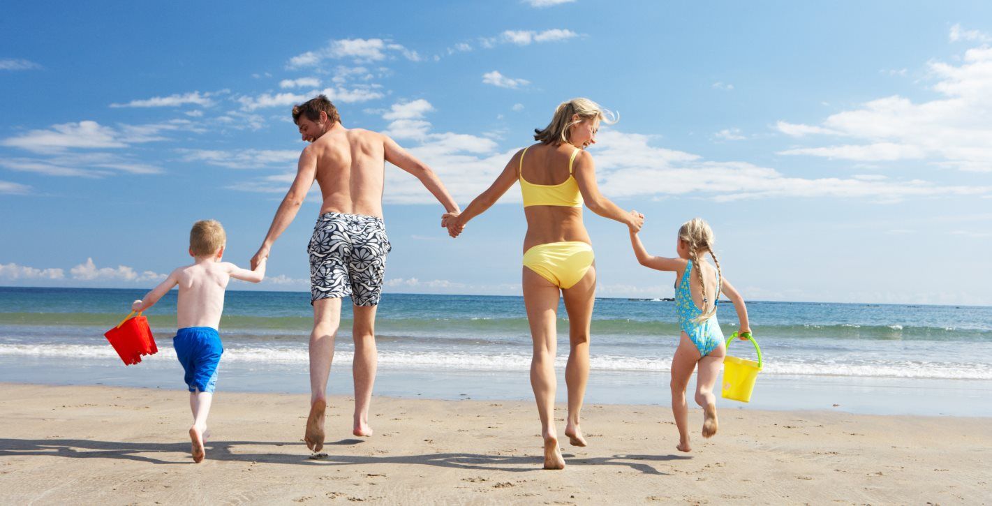 Family running toward the ocean together